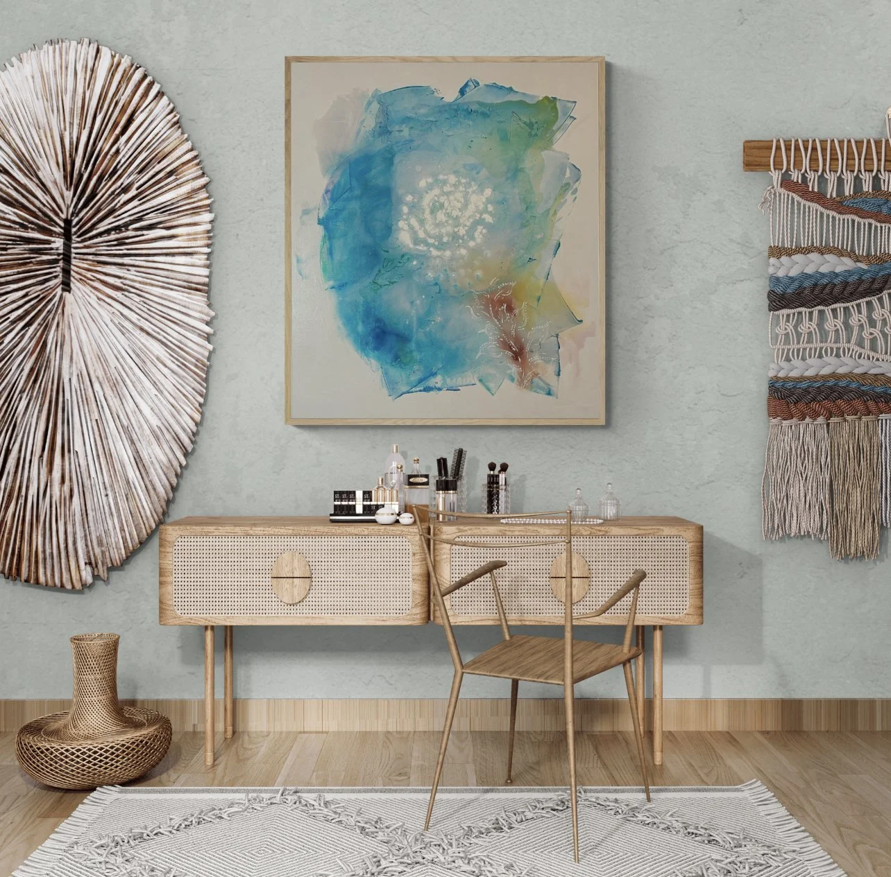 Decorative interior with a wooden vanity table, a wooden chair, abstract artwork in blue, green, and beige on the wall, woven wall art, and a white woven rug on a wooden floor.