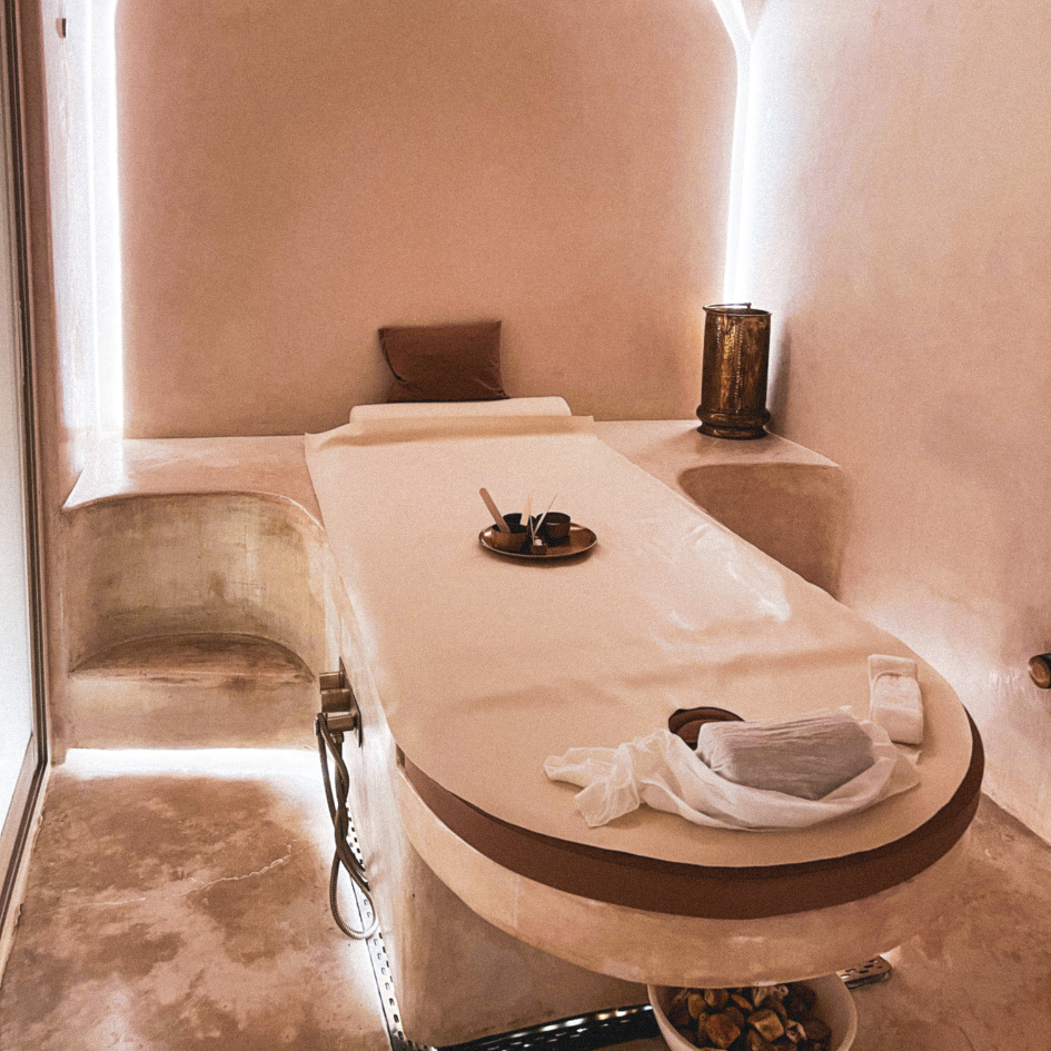 Minimalist spa treatment room with massage table and ambient lighting.