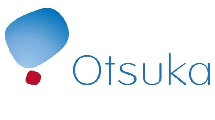 Otsuka logo featuring blue and red abstract shapes with company name in blue text