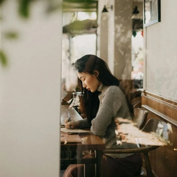 Woman writing questions to ask while preparing for therapy session.