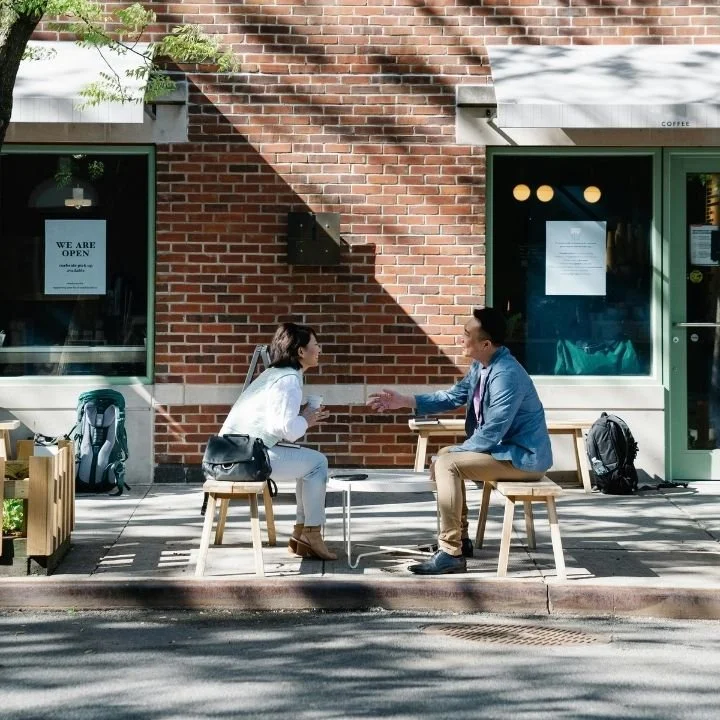Two adults talking outdoors illustrating therapy conversation and support.