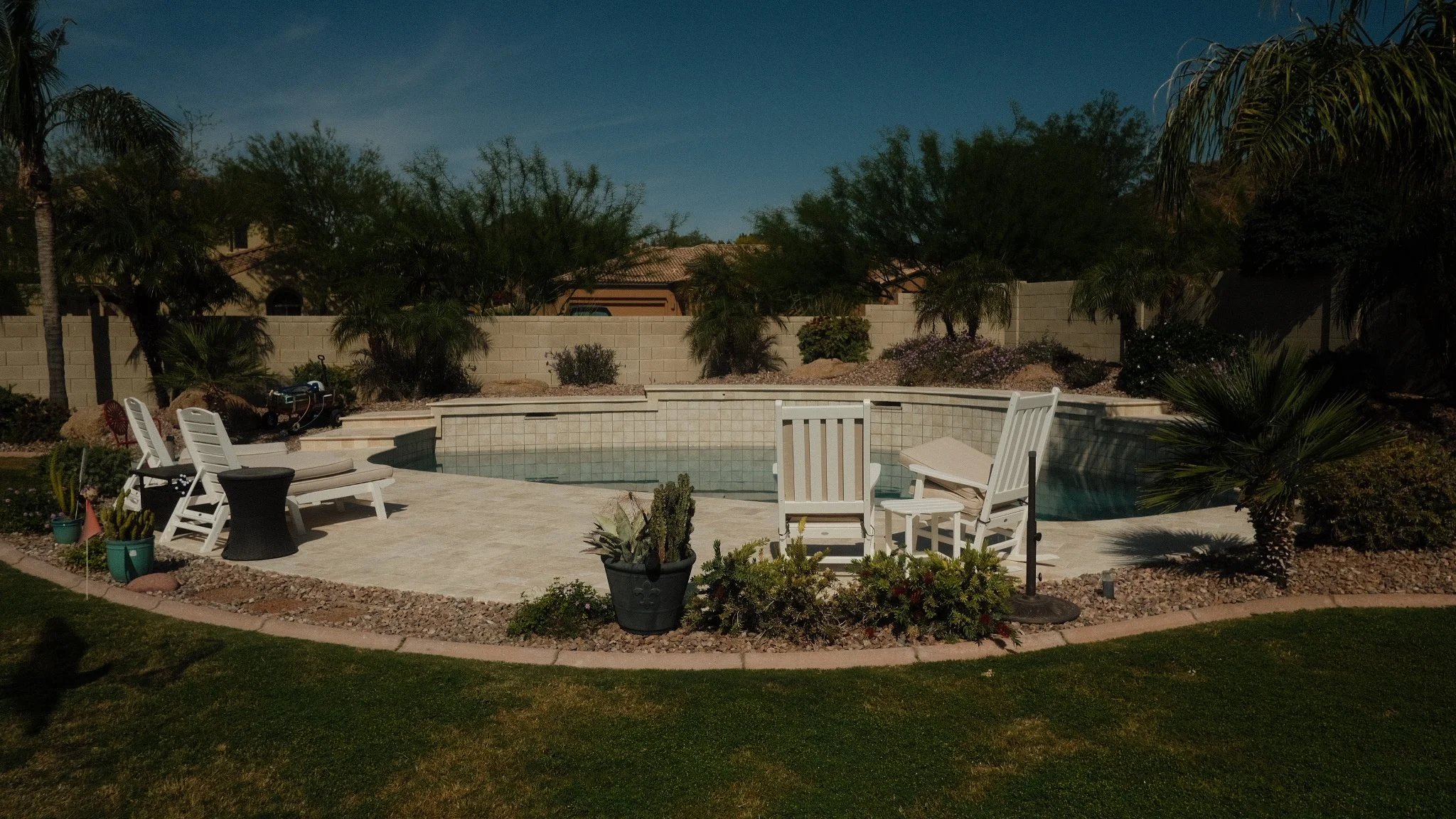 Wide shot of a luxurious, finished travertine pool deck installation in the Phoenix metropolitan area.