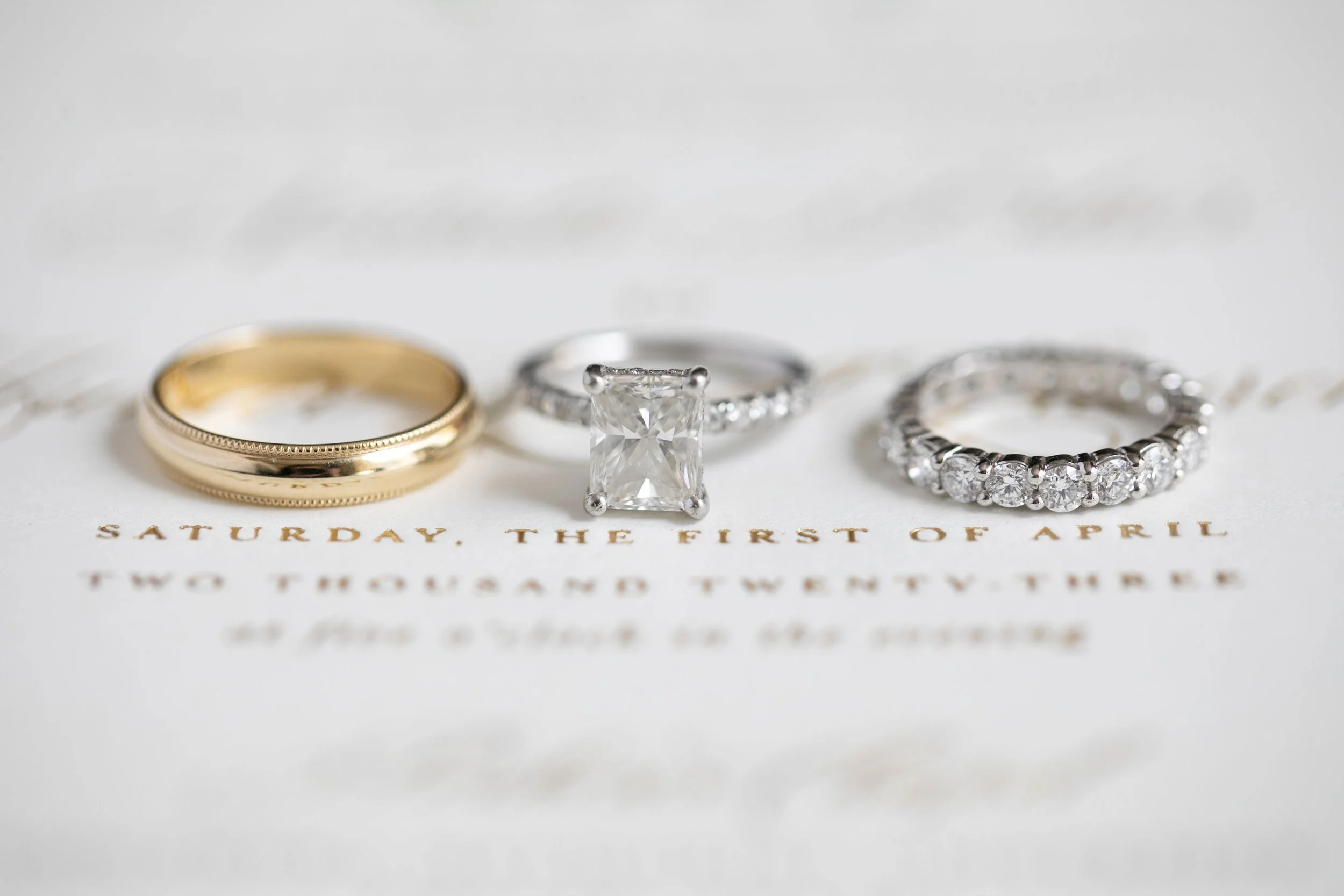 Four rings on a paper with gold and silver colors, with the text "Saturday, the first of April" visible.