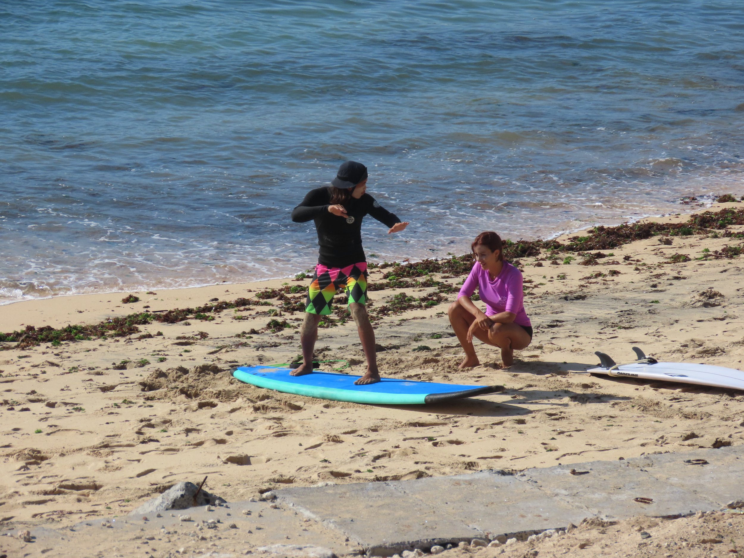 Rym Renom France French Peak Surf Bali Students at Padang Padang Beach Uluwatu Surfing Peak Surf Bali Surf School high five smiles fun happy joy friendship surfing beautiful beach crystal clear water white sand celebrity pink