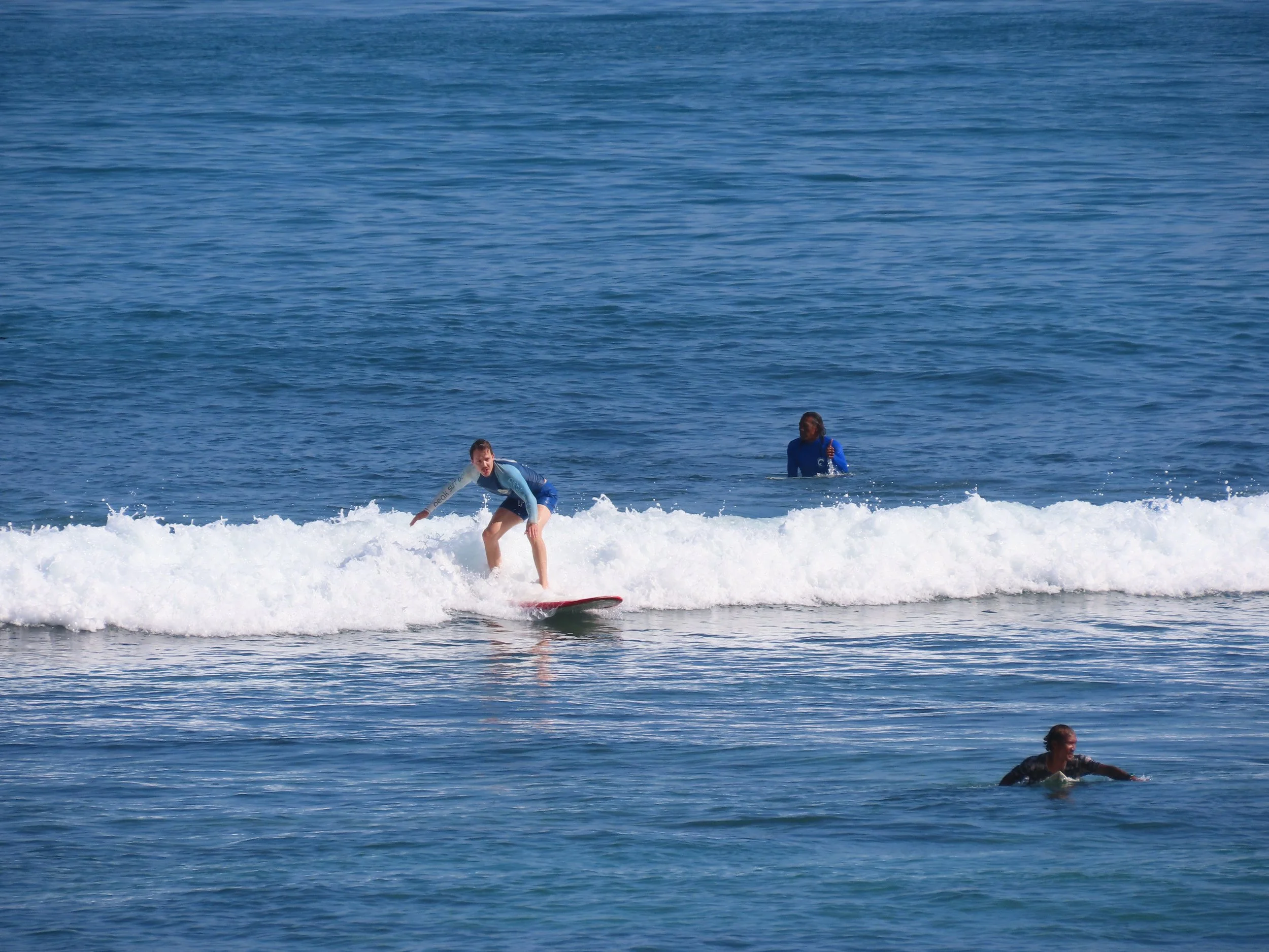 Peak Surf Bali Students at Padang Padang Beach Uluwatu Surfing Peak Surf Bali Surf School high five smiles fun happy joy friendship surfing beautiful beach crystal clear water white sand teaching surf surfer girl
