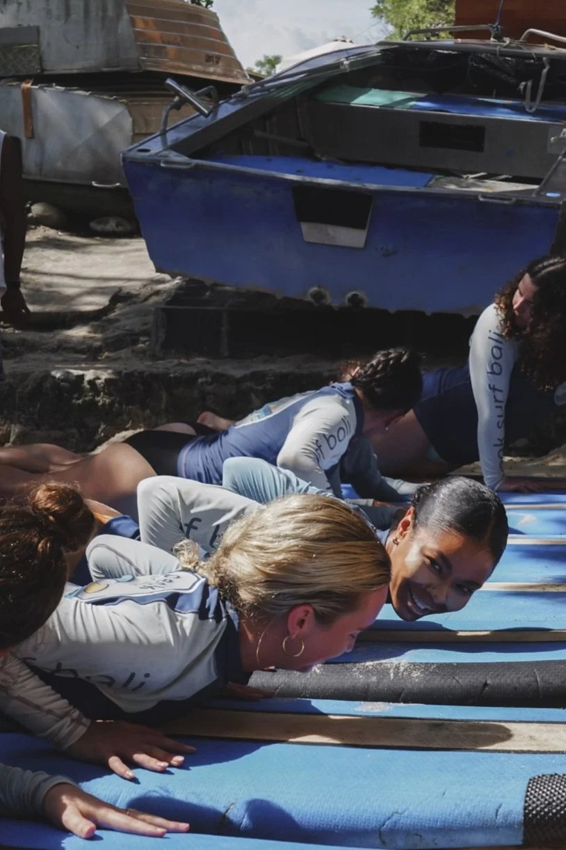 Peak Surf Bali Students at Padang Padang  surf theory Beach Uluwatu  Yoga Retreat Yoga with Jordan Surfing Peak Surf Bali Surf School high five smiles fun happy joy friendship surfing beautiful beach crystal clear water white sand putting Zinc on fac