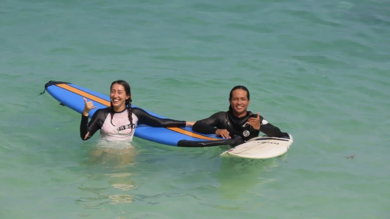 Peak Surf Bali Students at Padang Padang Beach Uluwatu Surfing Peak Surf Bali Surf School high five smiles fun happy joy friendship surfing beautiful beach crystal clear water white sand teaching surf surfer girl