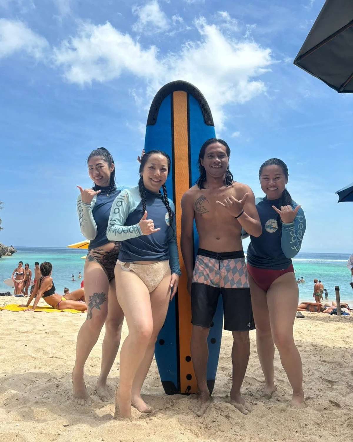 Peak Surf Bali Students at Padang Padang Beach Uluwatu Surfing Peak Surf Bali Surf School high five smiles fun happy joy friendship surfing beautiful beach crystal clear water white sand teaching surf surfer girl