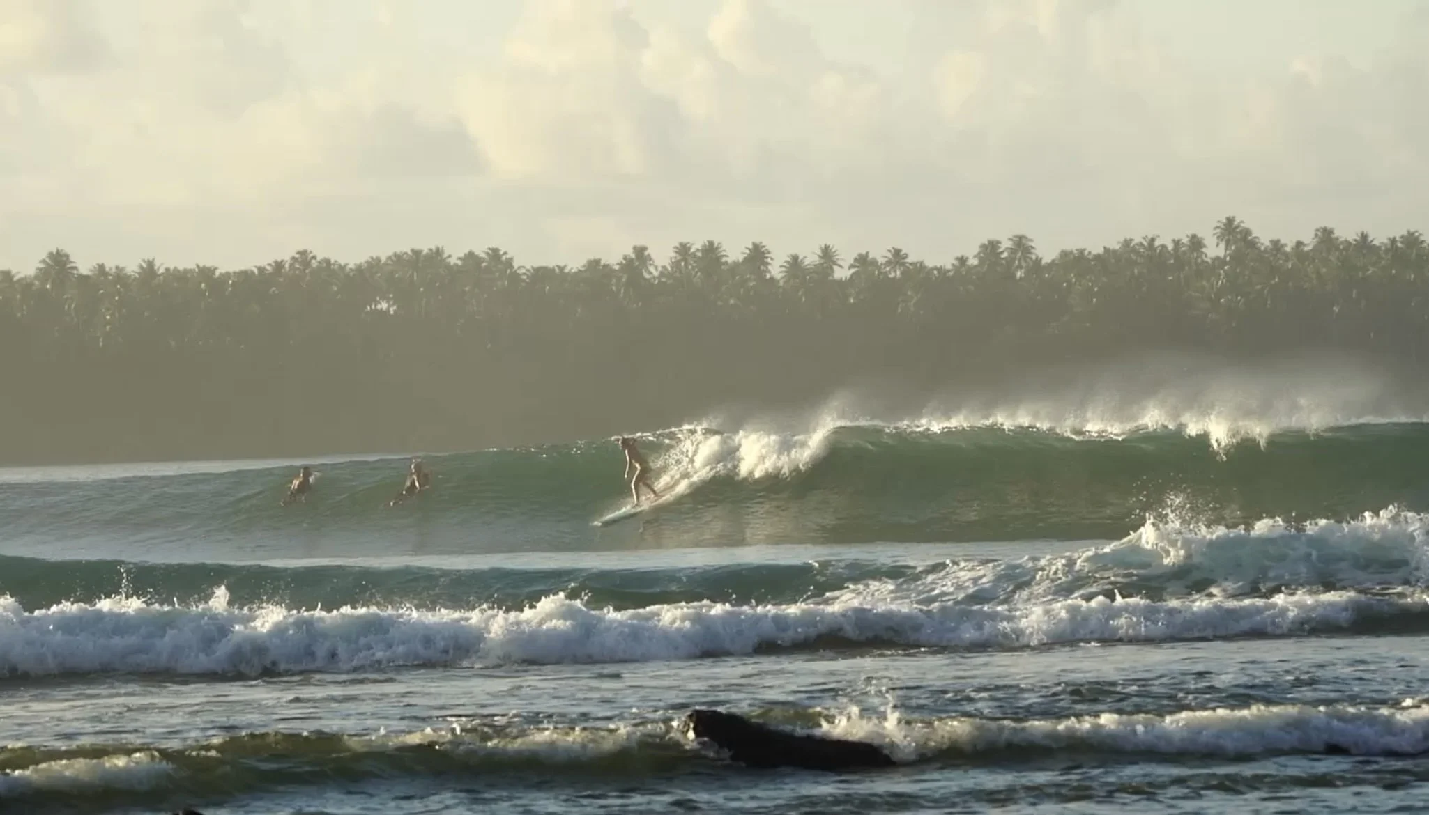 Peak Surf Bali Students at Surf Trip - Nias North Sumatra Surfing Peak Surf Bali Surf School high five smiles fun happy joy friendship surfing beautiful beach crystal clear water white sand teaching surf surfer girl
