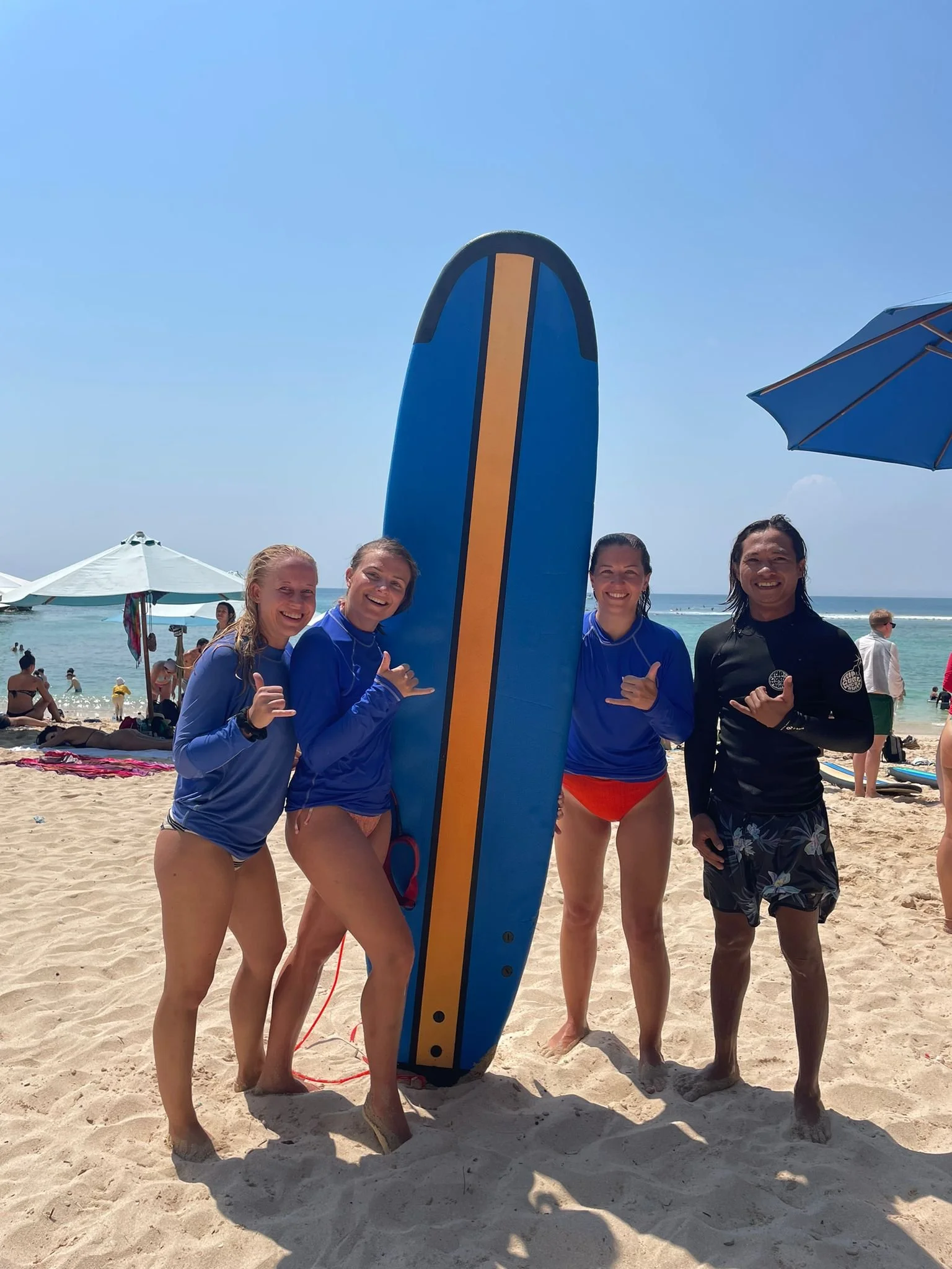 Peak Surf Bali Students at Padang Padang Beach Uluwatu Surfing Peak Surf Bali Surf School high five smiles fun happy joy friendship surfing beautiful beach crystal clear water white sand teaching surf surfer girl