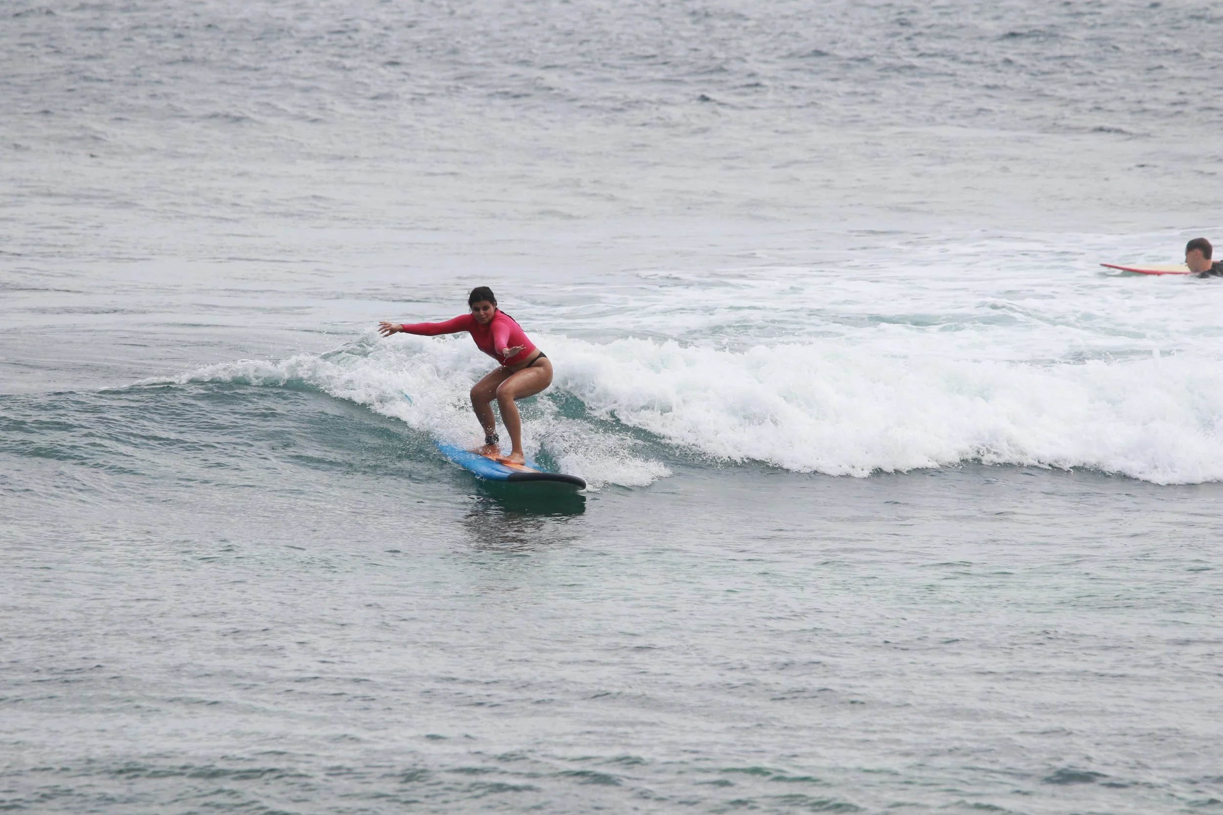 Peak Surf Bali Students at Padang Padang Beach Uluwatu Surfing Peak Surf Bali Surf School high five smiles fun happy joy friendship surfing beautiful beach crystal clear water white sand teaching surf surfer girl From India Mihra