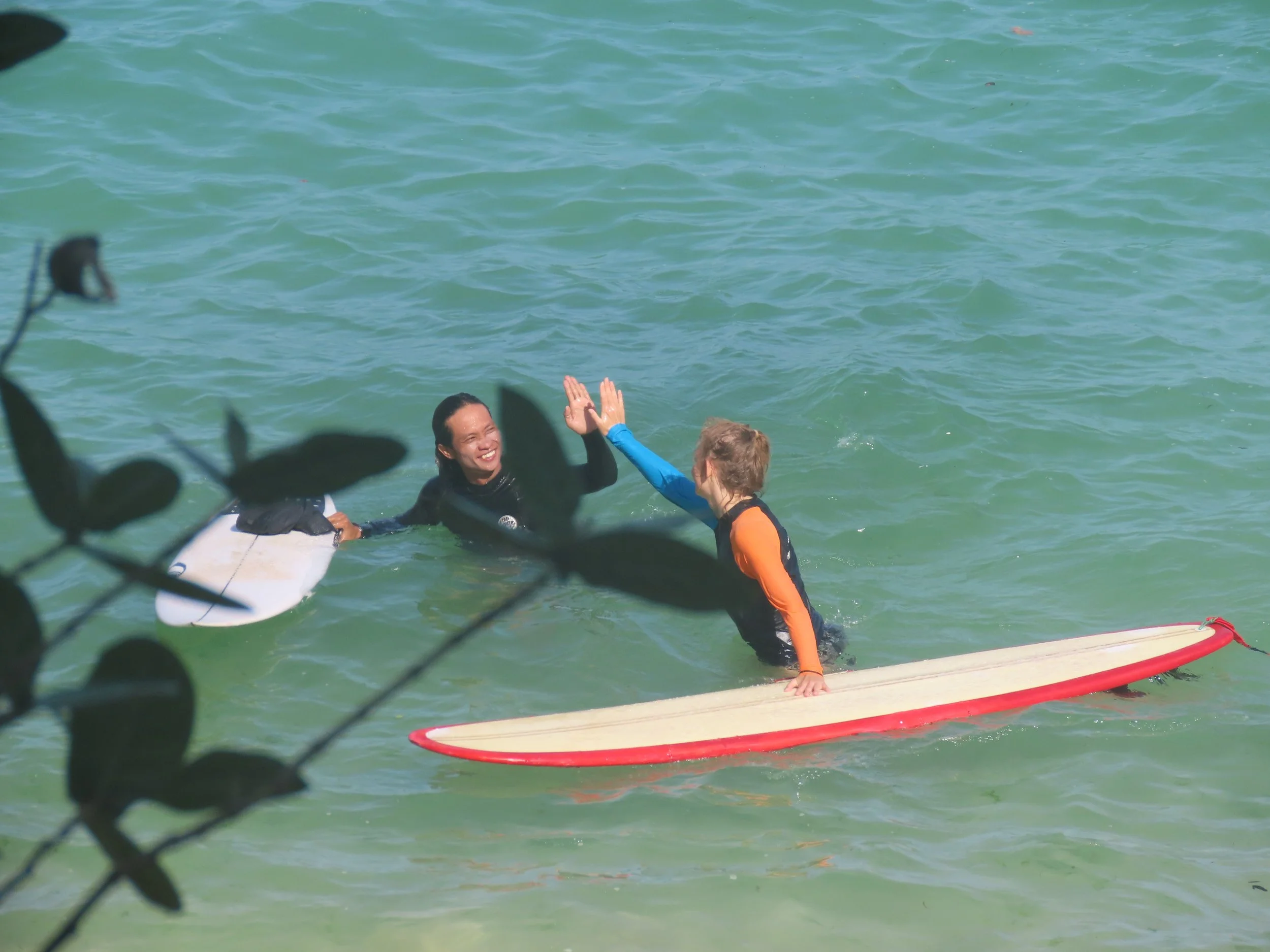 Peak Surf Bali Students at Padang Padang Beach Uluwatu Surfing Peak Surf Bali Surf School high five smiles fun happy joy friendship surfing beautiful beach crystal clear water white sand