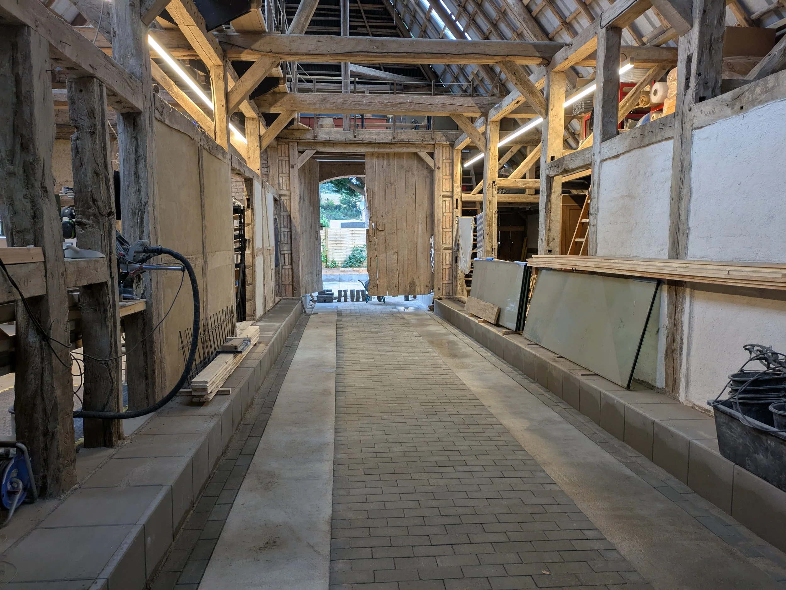 Inneneinrichtung eines Holzhauses im Bau, mit Sicht auf den Flur, Baustoffe und Holzstruktur, und handwerkerähnlicher Baustellenatmosphäre.