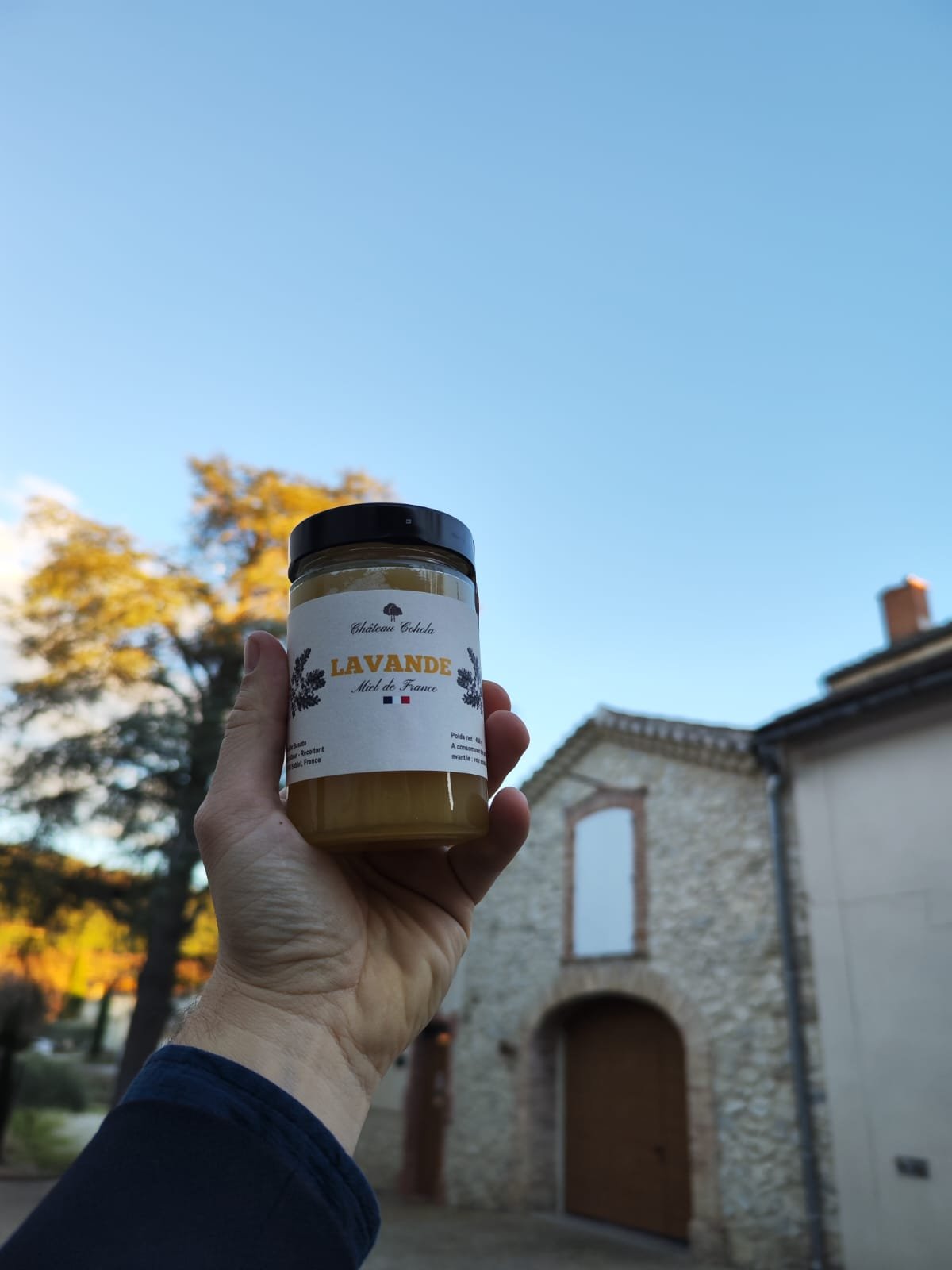 Pot de miel de lavande devant ancienne grange restaurée