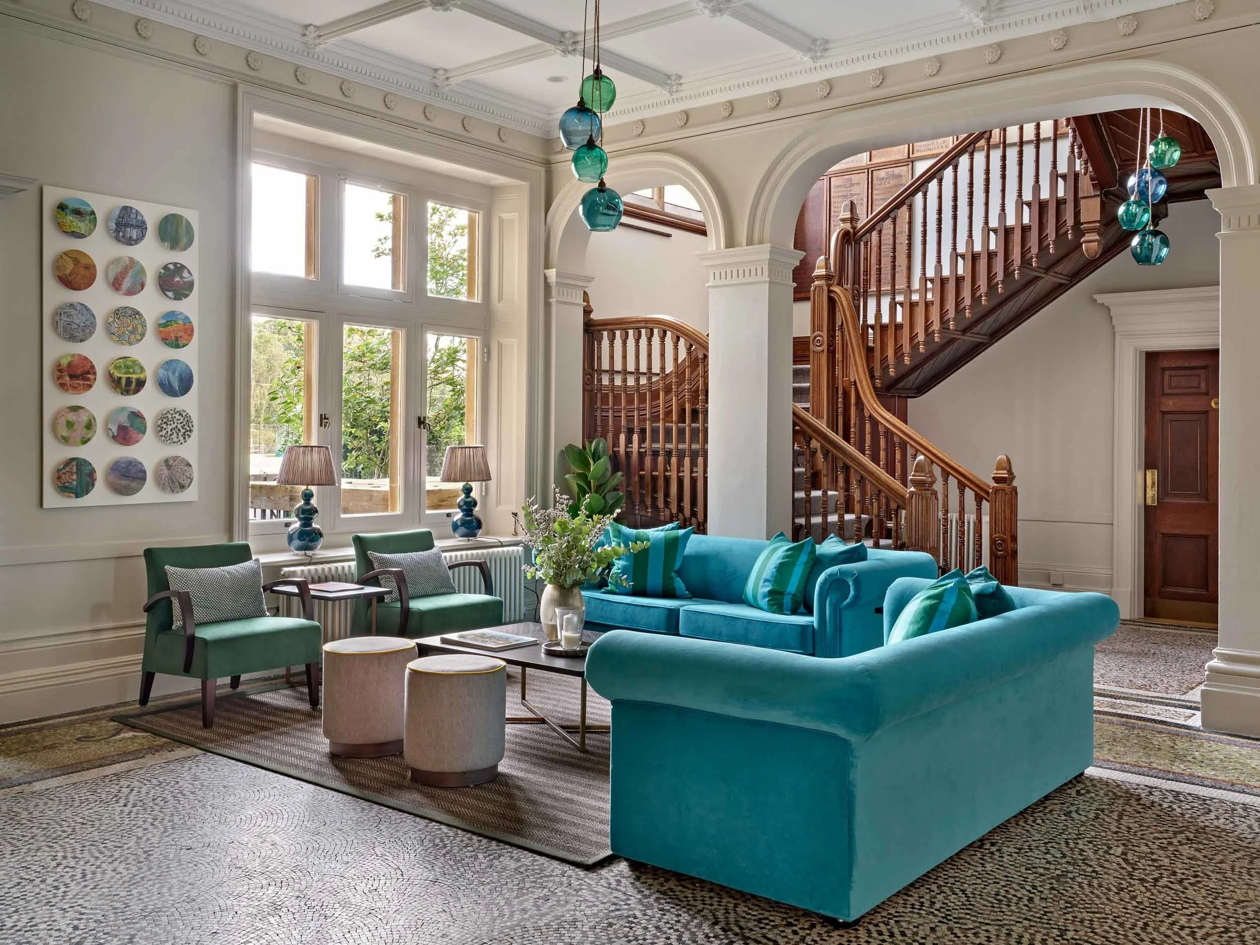 teal-green-velvet-sofa-chairs-large-window-light-seating-area-school