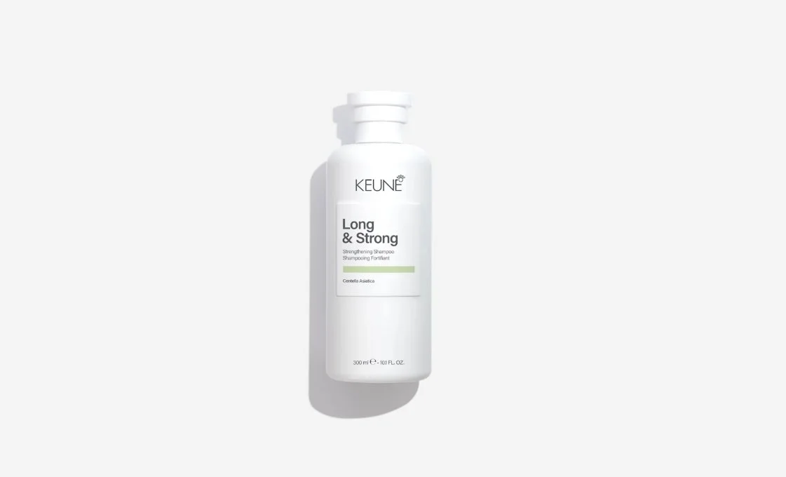 A white bottle of Keune Long & Strong strengthening shampoo with a minimalist design, labeled with product details, placed on a white background.