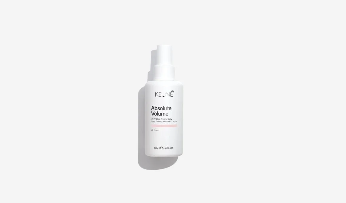 A white spray bottle labeled 'KEUNE Absolute Volume Lift And Grip Thermal Spray' with lily extract, placed on a white background with shadow.