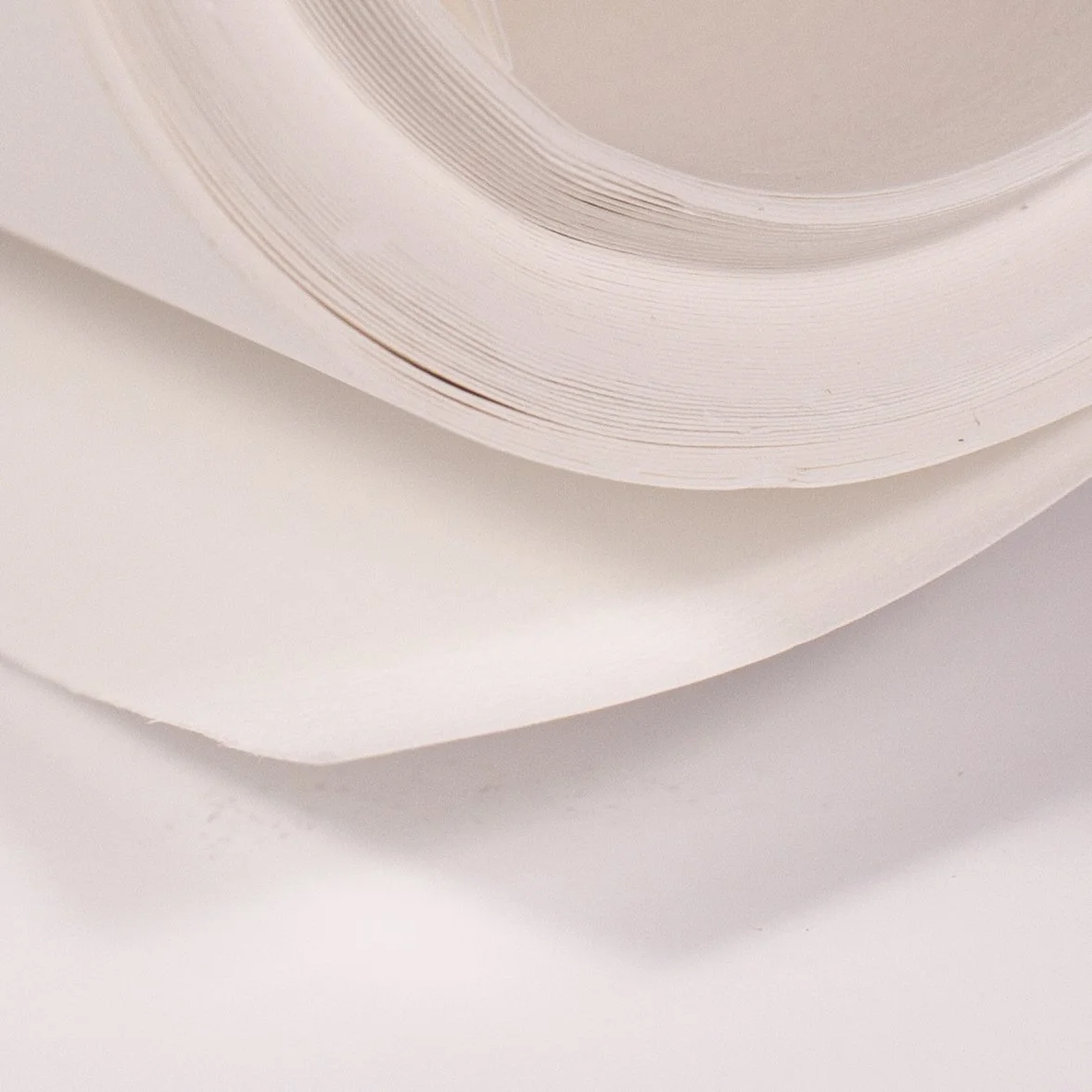 Close-up of metallic paper plates stacked on top of white plates.