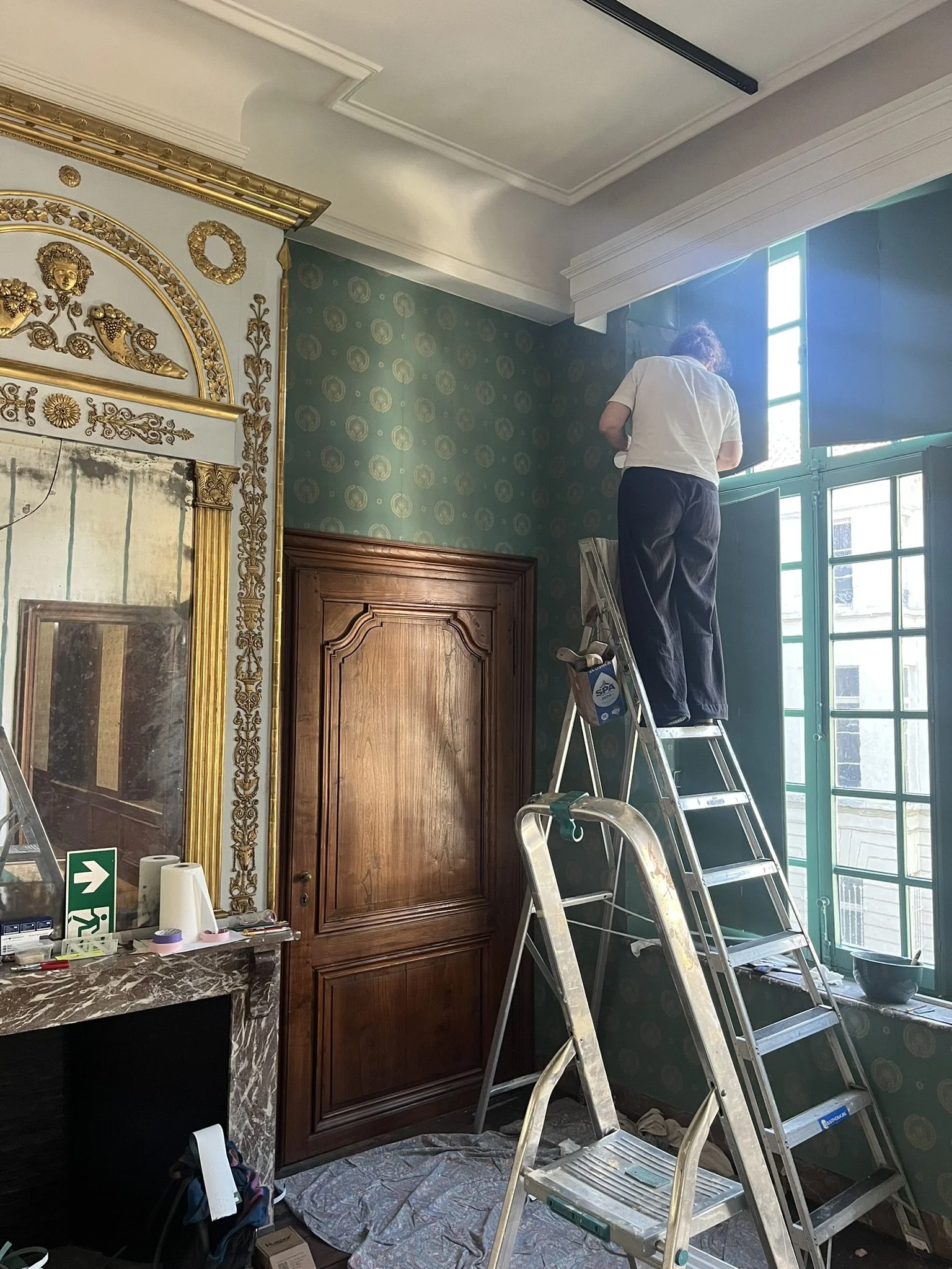 Hanging a reproduction blockprinted wallpaper at the designmuseum in Ghent