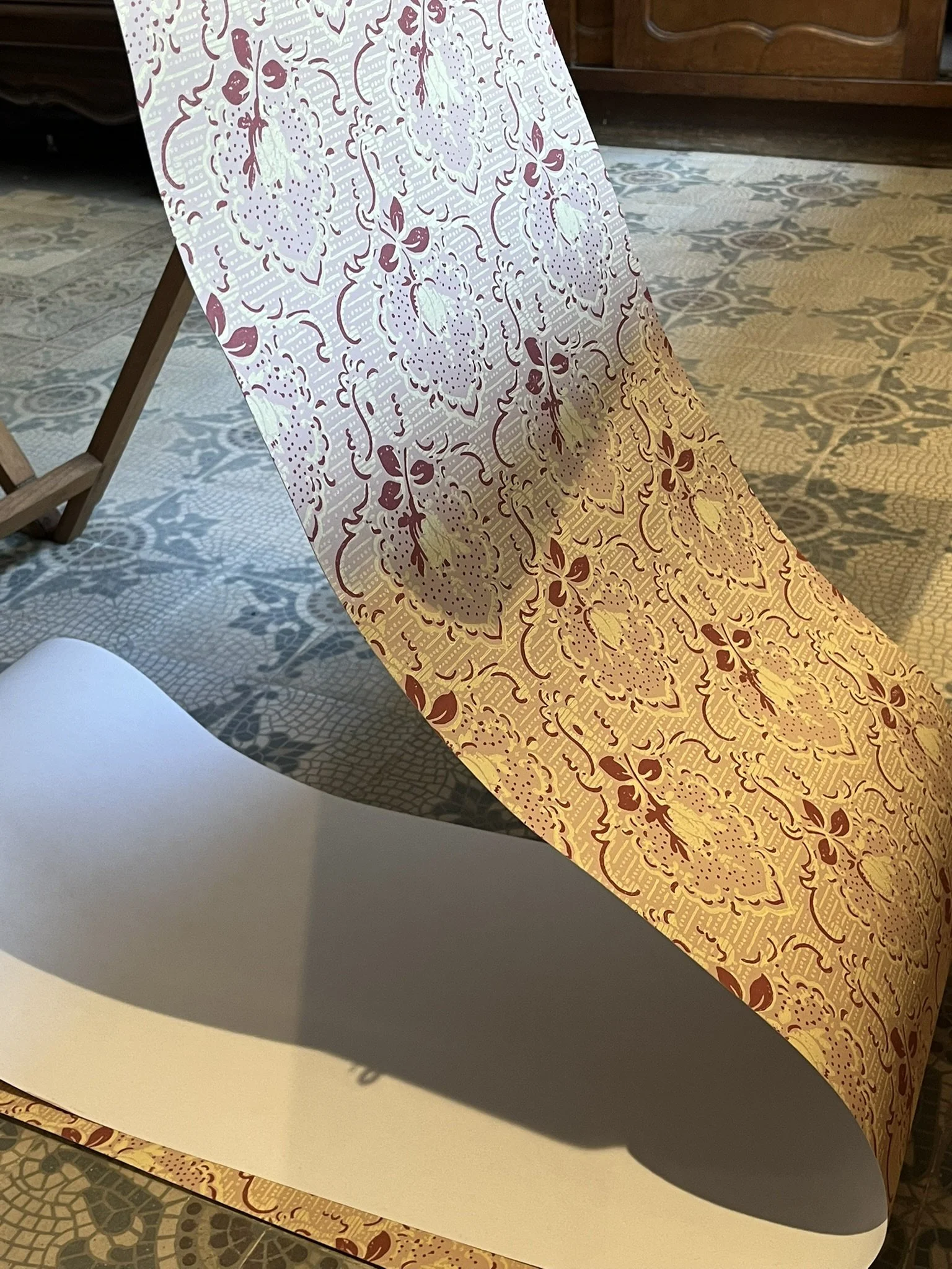 Wallpaper hanging from the table, ready to be hung on the wall