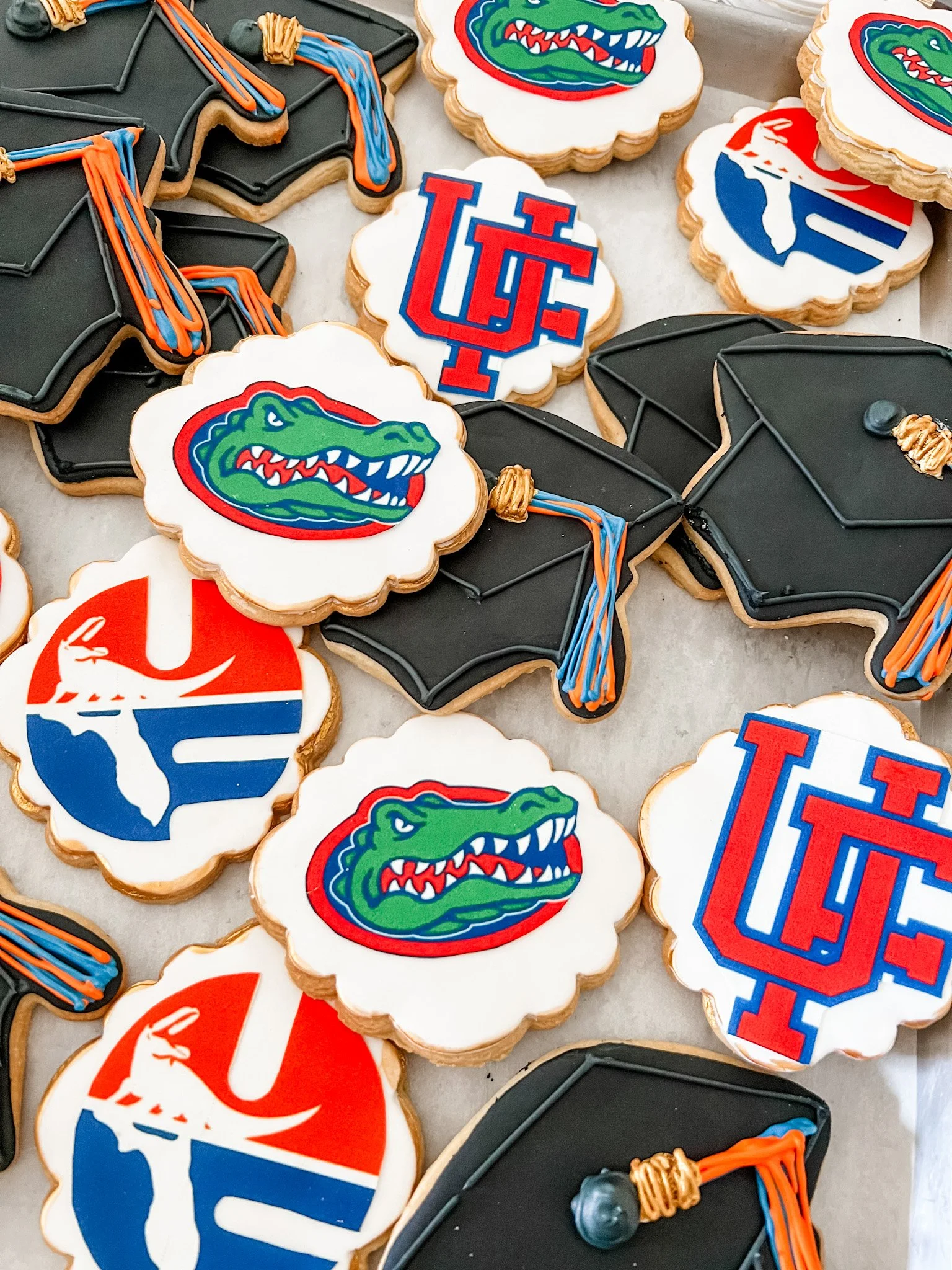 custom decorated graduation sugar cookies with the university of florida gators and graduation caps