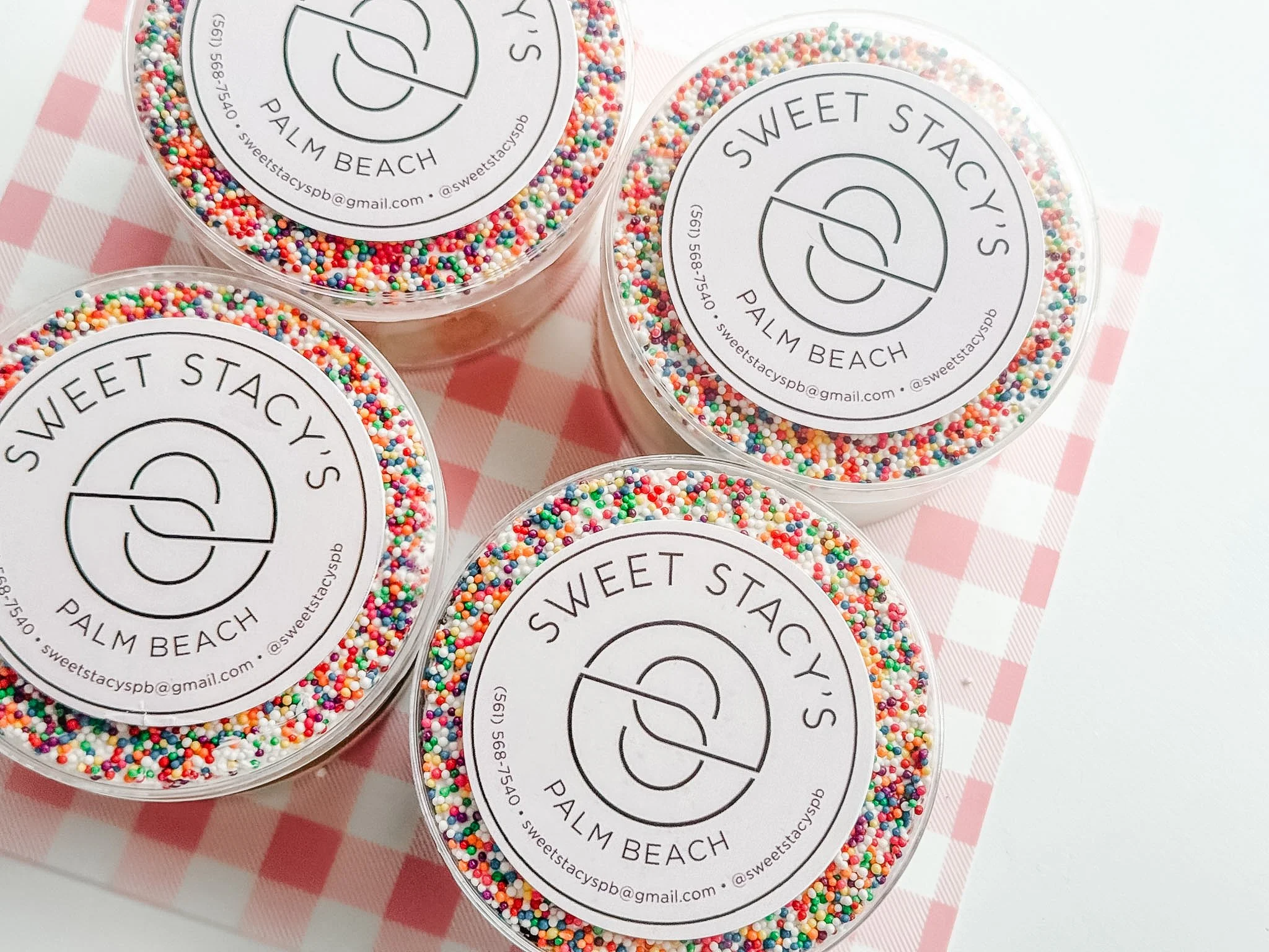 individually packaged vanilla and chocolate dot cakes in clear containers with the sweet Stacys logo with frosting and rainbow sprinkles