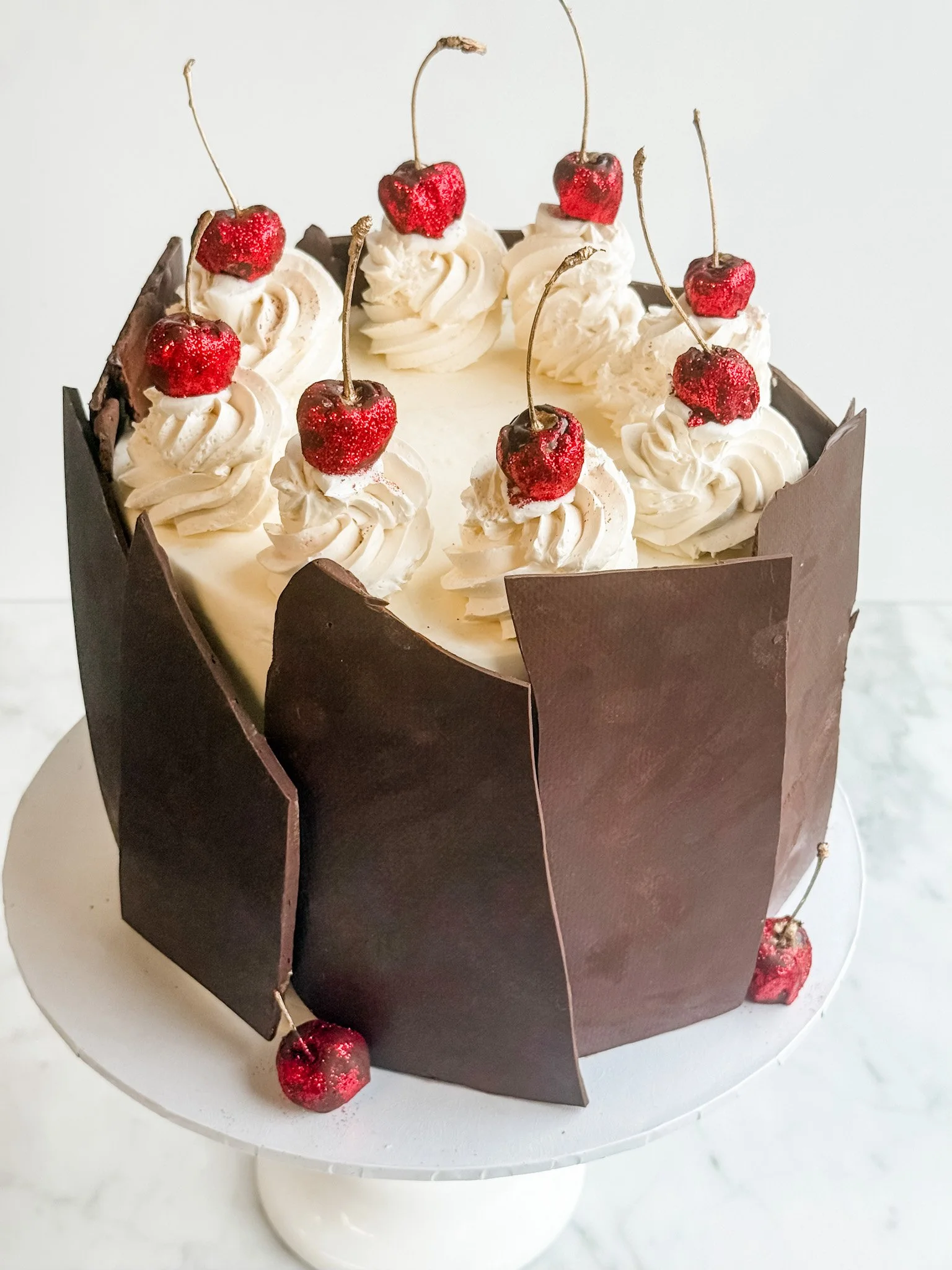 decadent Black Forest cake adorned with chocolate, whipped cream, and cherries on top