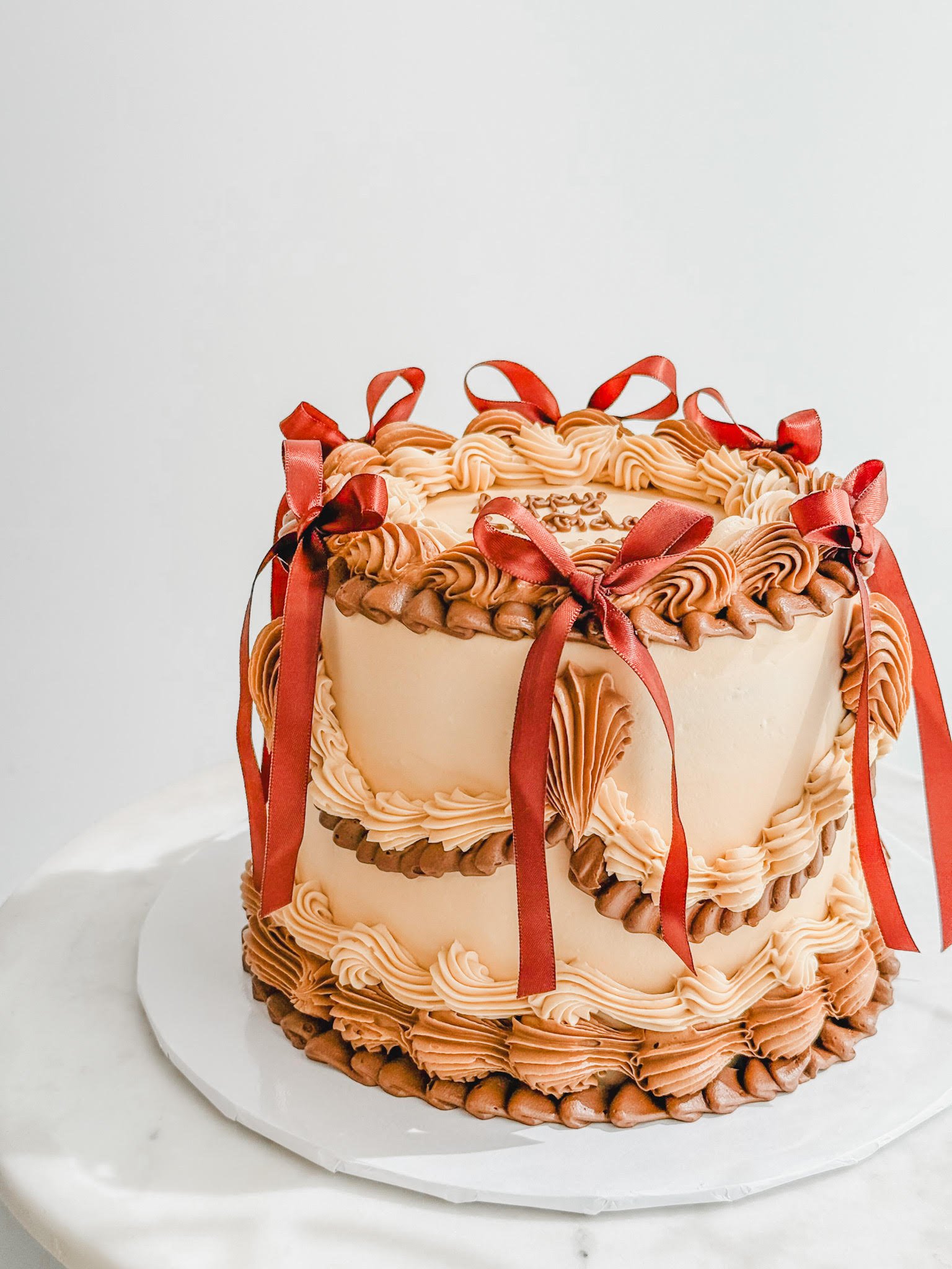 round vintage cake decorated with hand piped icing and bows