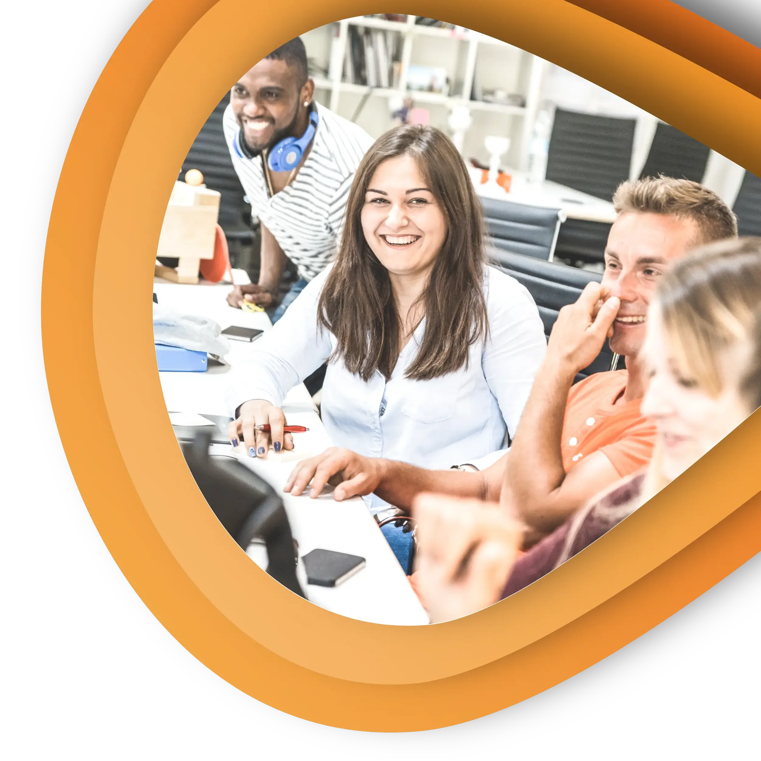 A team of people sat together in an office smiling and talking