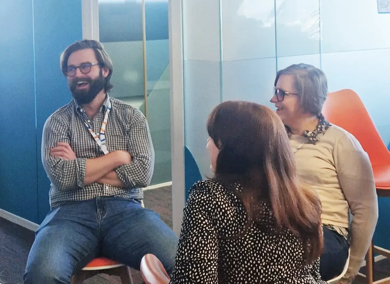 Clarion team members sit together talking and laughing