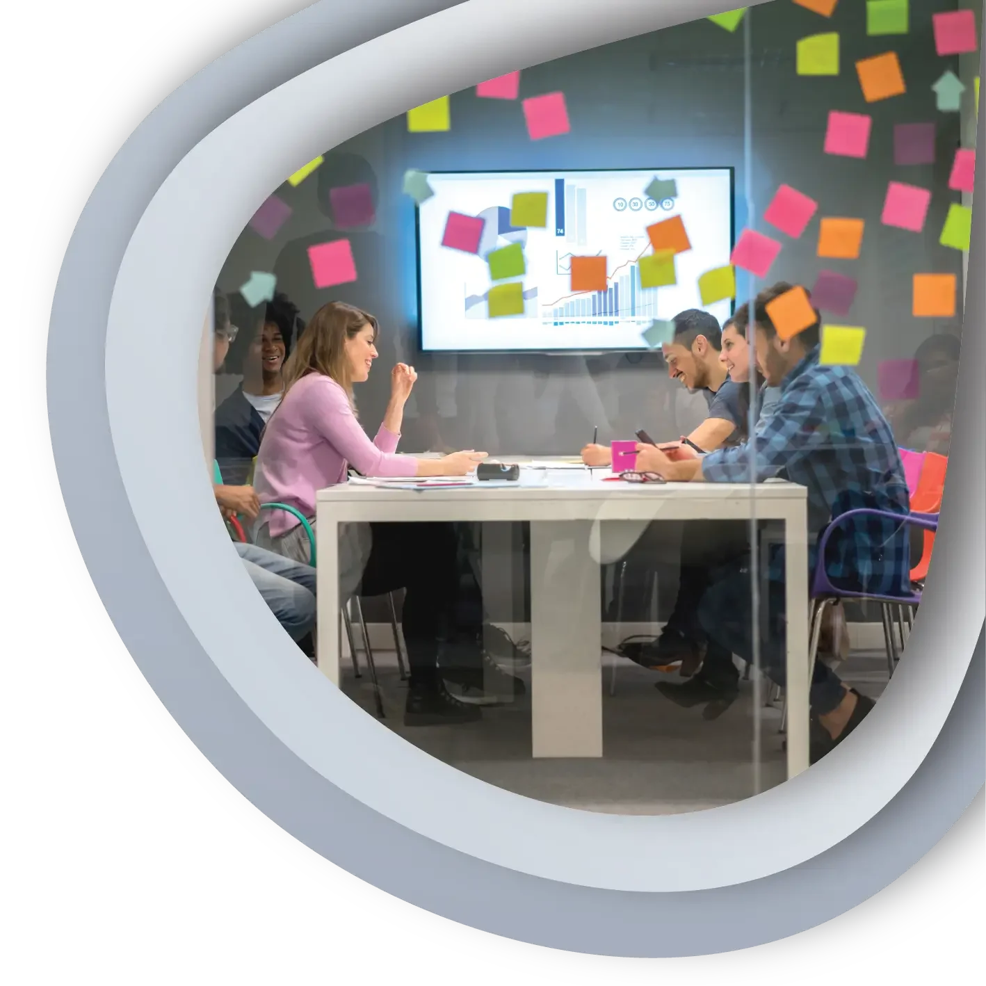 Team of people in a meeting with post it notes and a large tv on the wall
