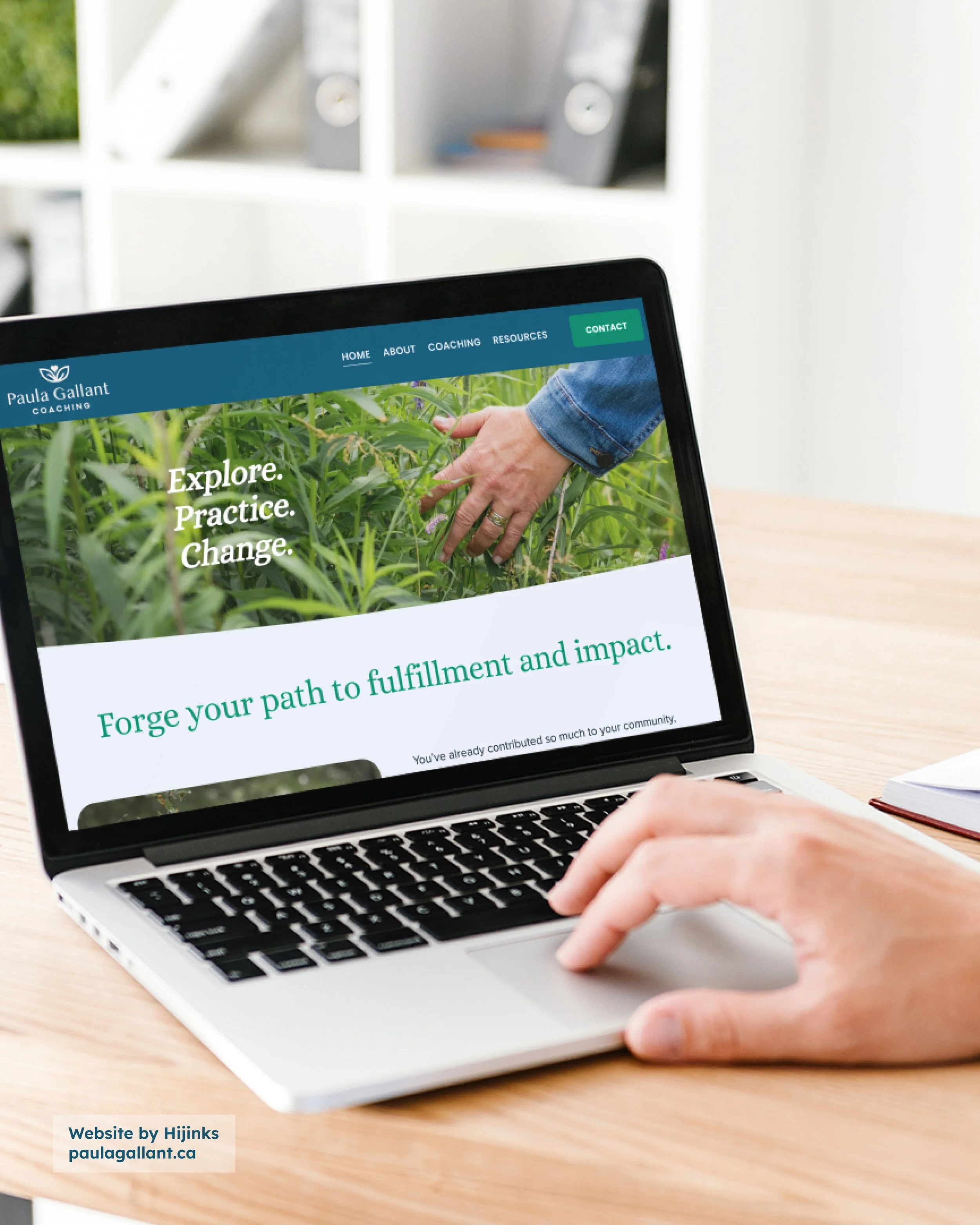A person using a laptop on a wooden desk shows a website for Paula Gallant Coaching with a green and blue color scheme. The website features a hand touching plants and text reading 'Explore. Practice. Change.' and 'Forge your path to fulfillment and 
