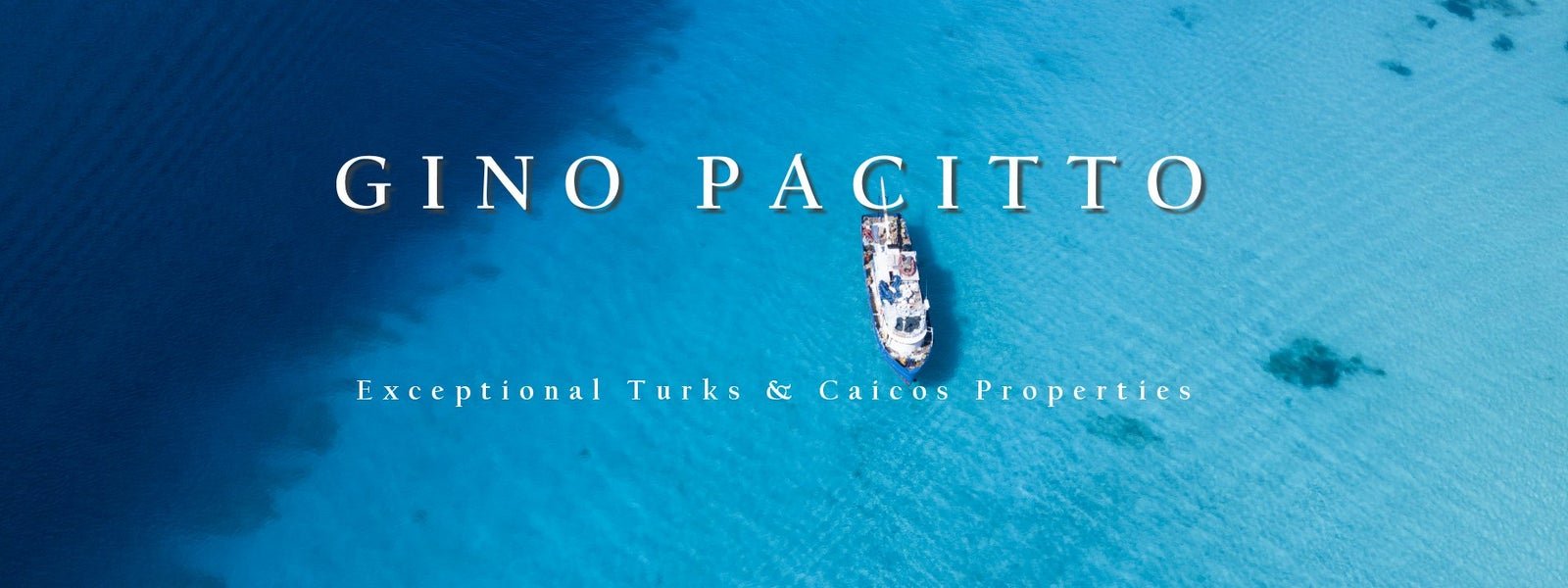 Aerial view of a boat in clear blue ocean water with text: "Gino Pacitto" and "Exceptional Turks & Caicos Properties."