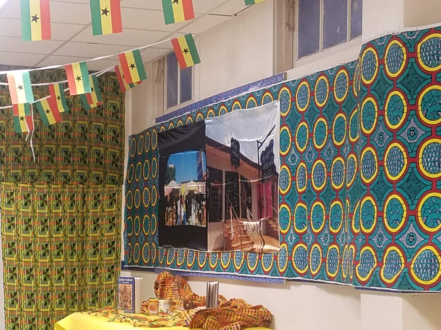 School visit display with flags of Ghana, photos and textiles on bulletin board