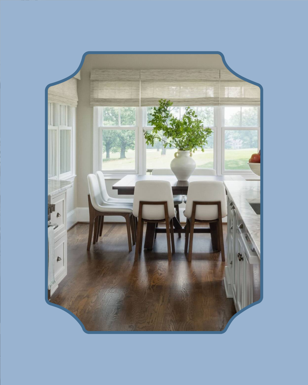 Photo of a kitchen, looking towards a dining table with chairs around it.