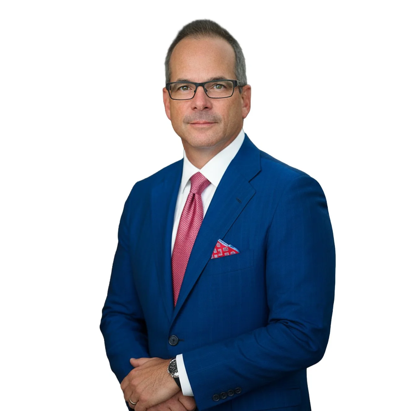 A photo of Bill Reid, a professional man in a blue suit with a pink tie and a red patterned pocket square, wearing glasses, standing against a white background.