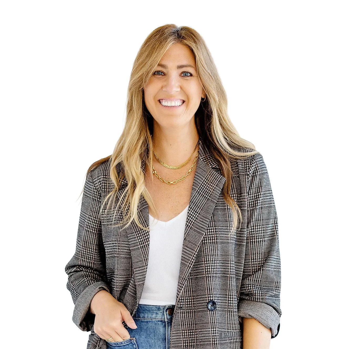 A smiling woman with blonde hair wearing a plaid blazer, white top, and gold jewelry against a plain white background.