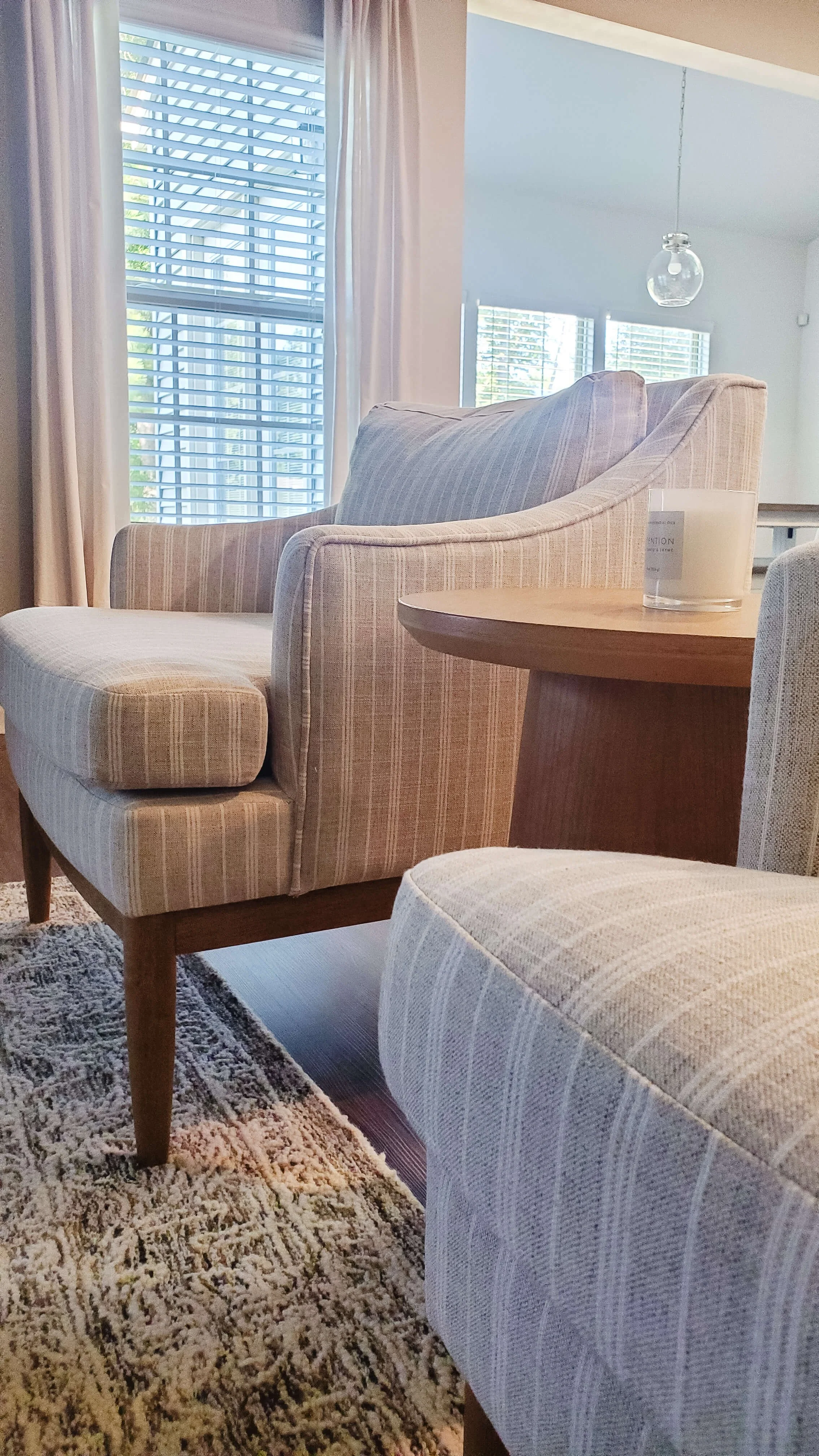Striped upholstered accent chairs around a round wood pedestal table.jpg