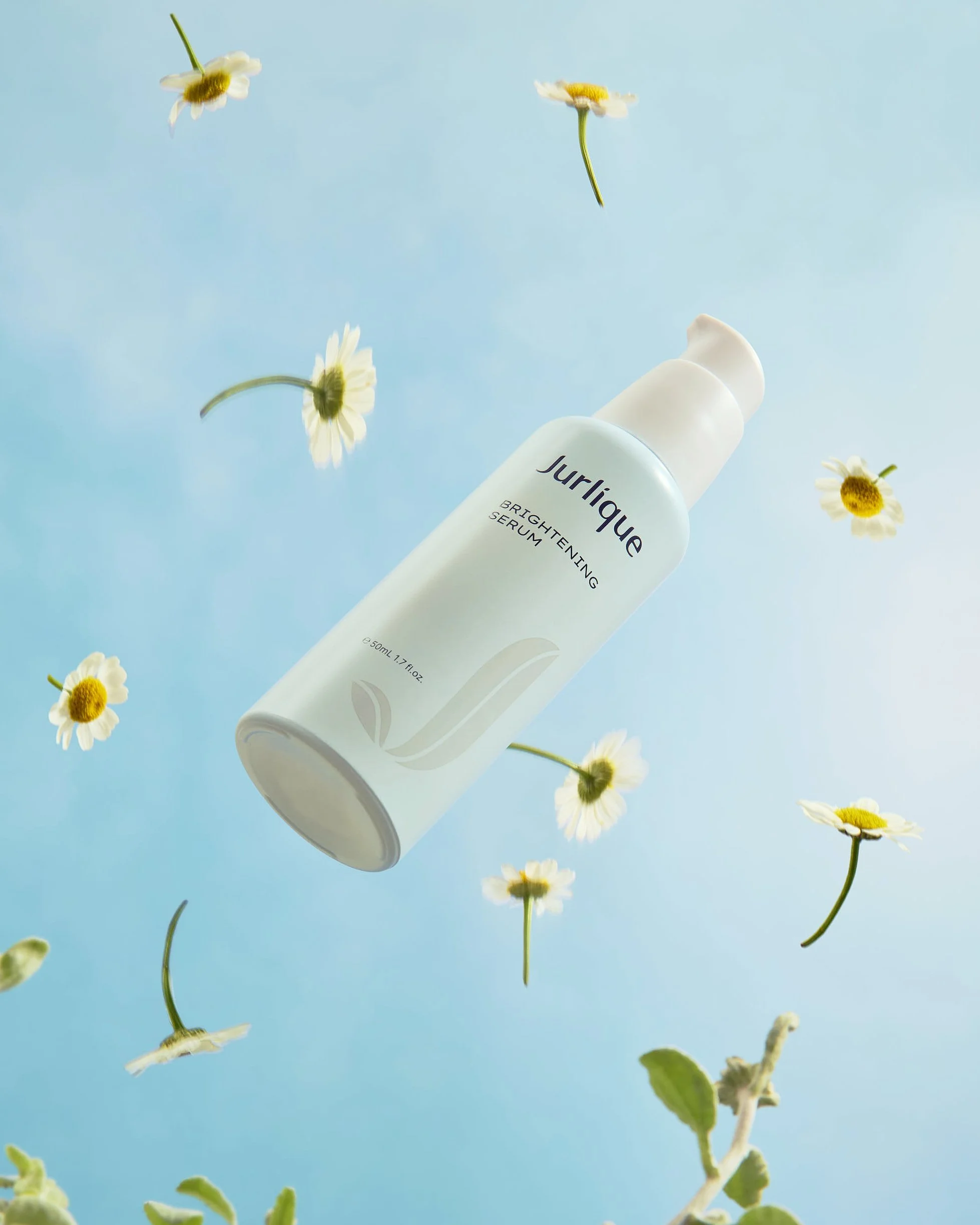 A white bottle of Jurlique Brightening Serum on a light blue background with white daisies floating around.