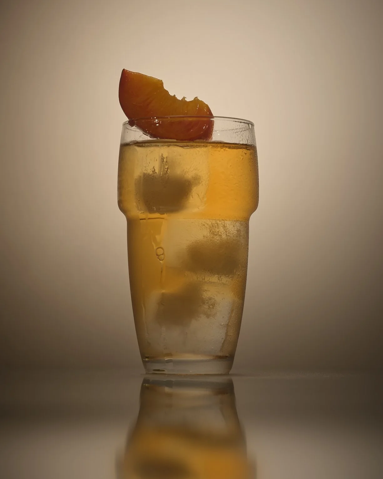 A glass of iced tea with a lemon wedge on top
