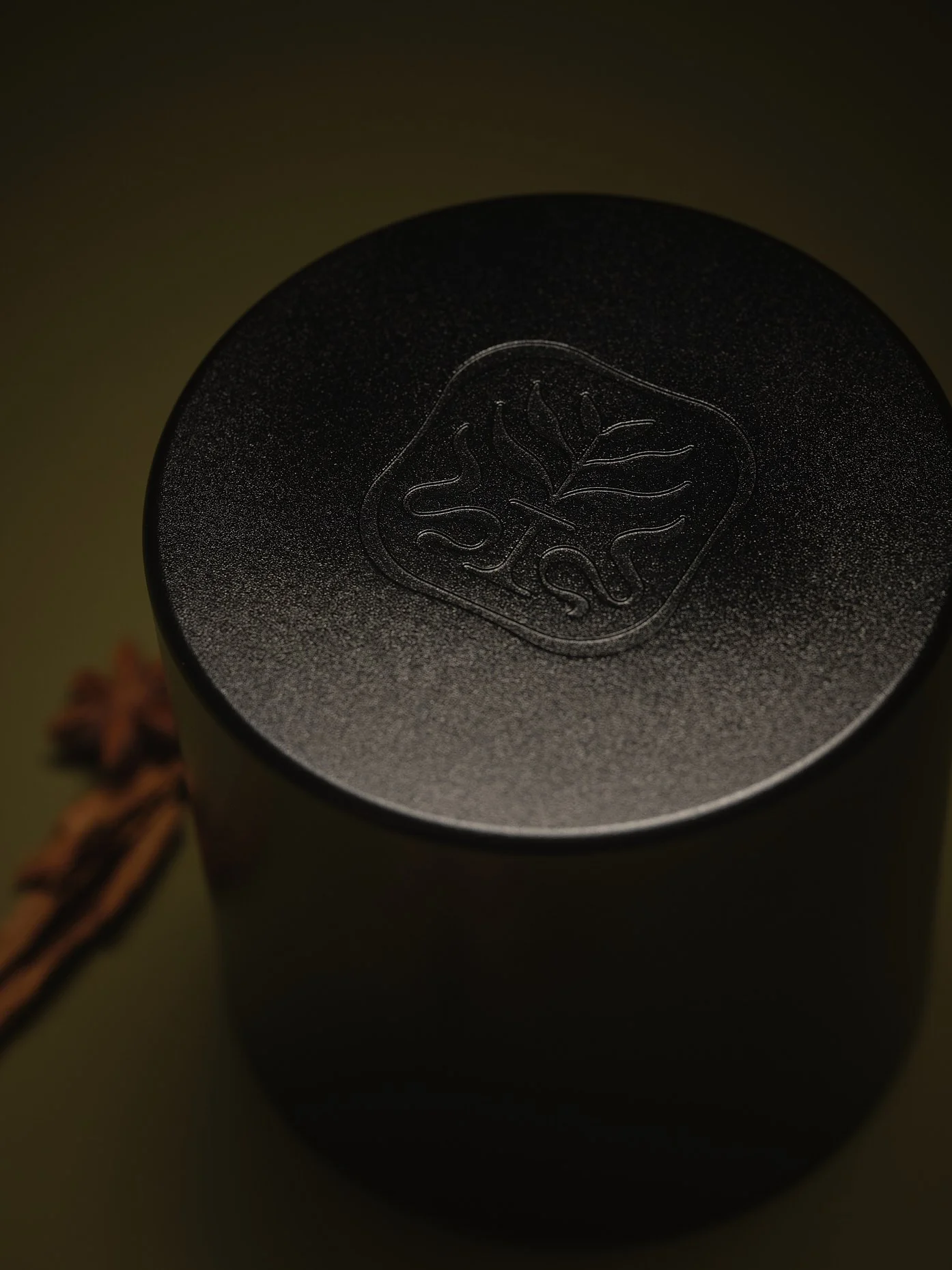 Close-up of a black cylindrical container with a raised emblem of a leaf and the text 'SIL' on top.