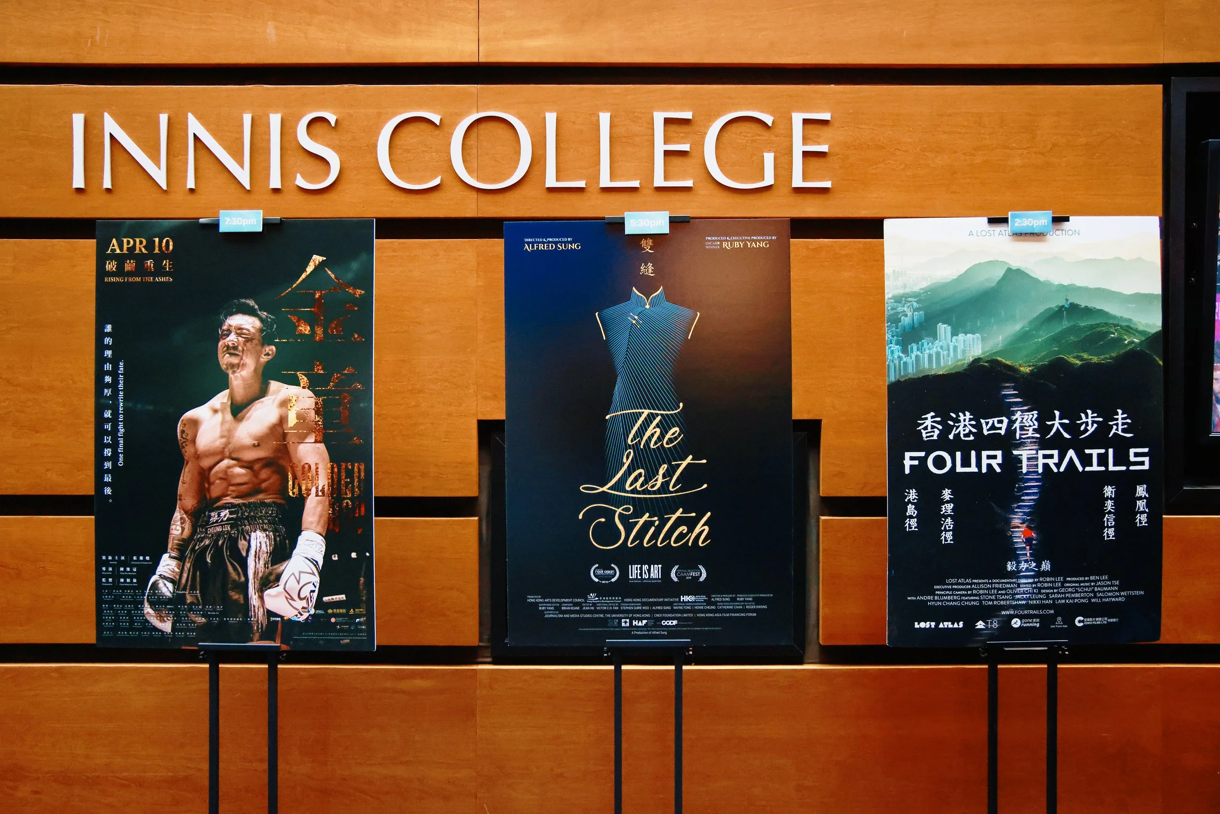 Three film posters displayed on the wooden wall at Innis College for the Reflections & Refractions 港·映 Charity Screening Day