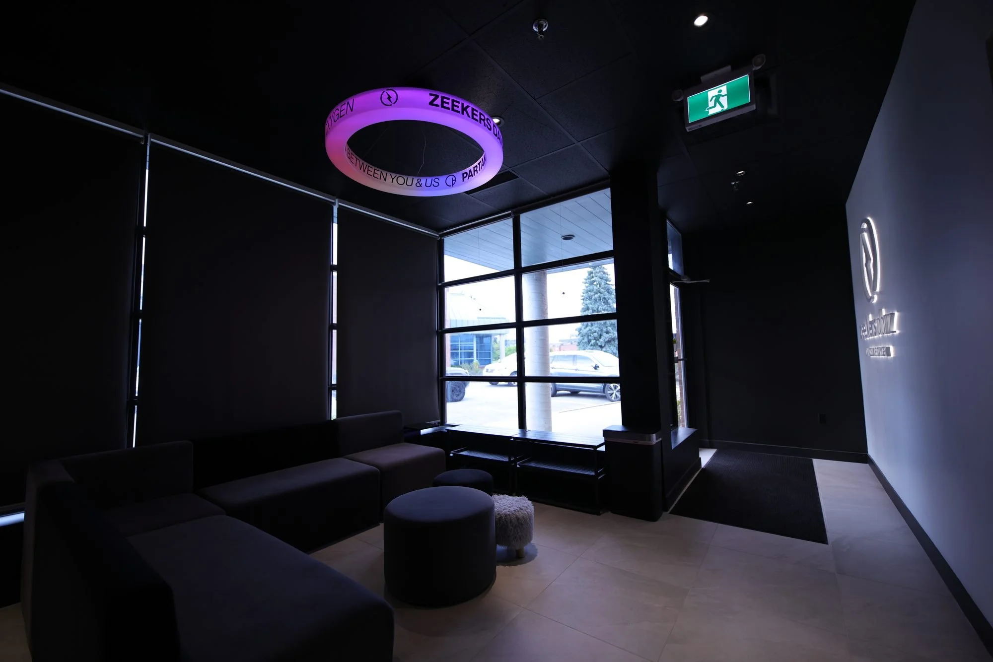 The studio lounge: black sofas under a glowing ring light.