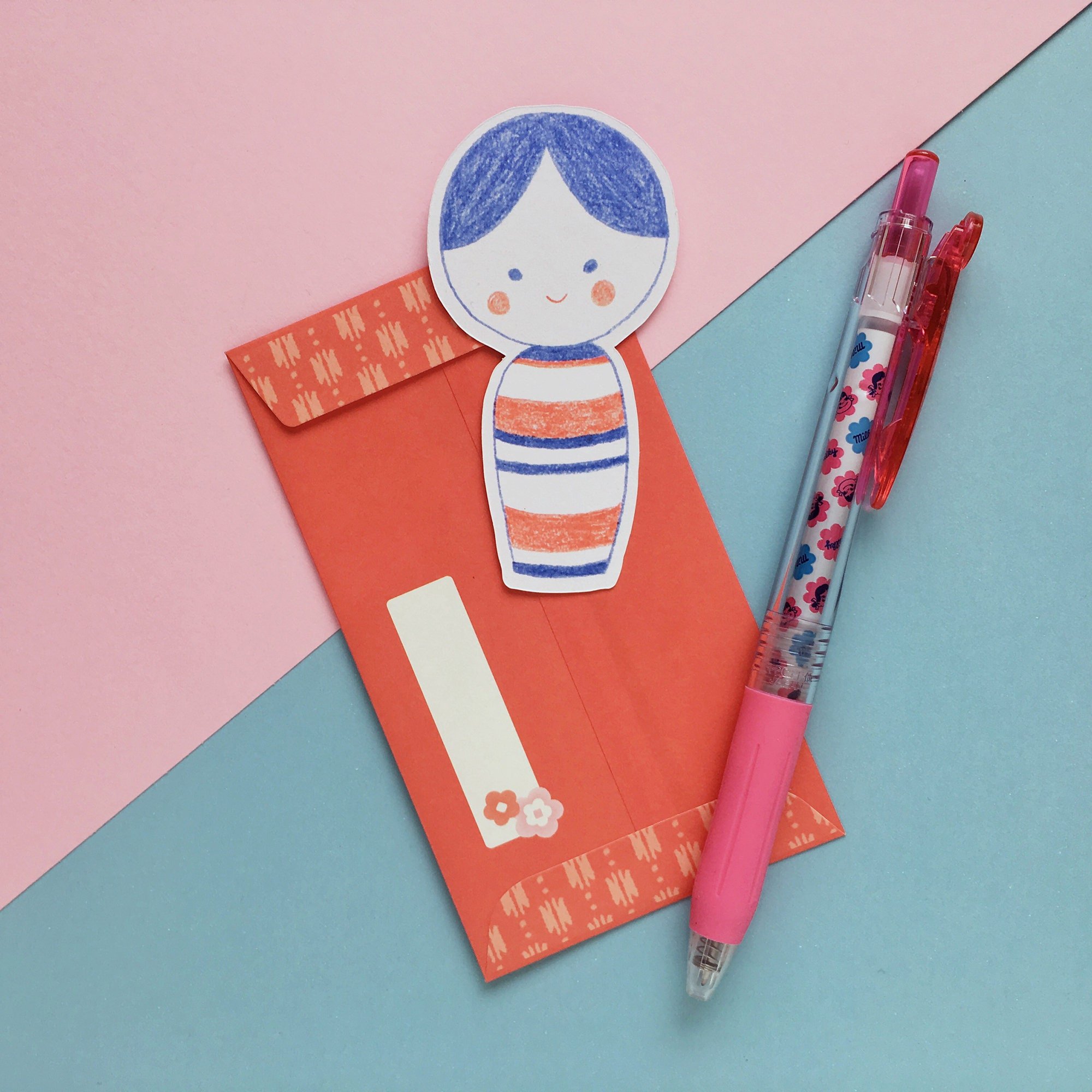 Die cut kokeshi doll note card displayed with an envelope and pen
