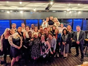 Group of people posing for a photo at a social event, indoors.
