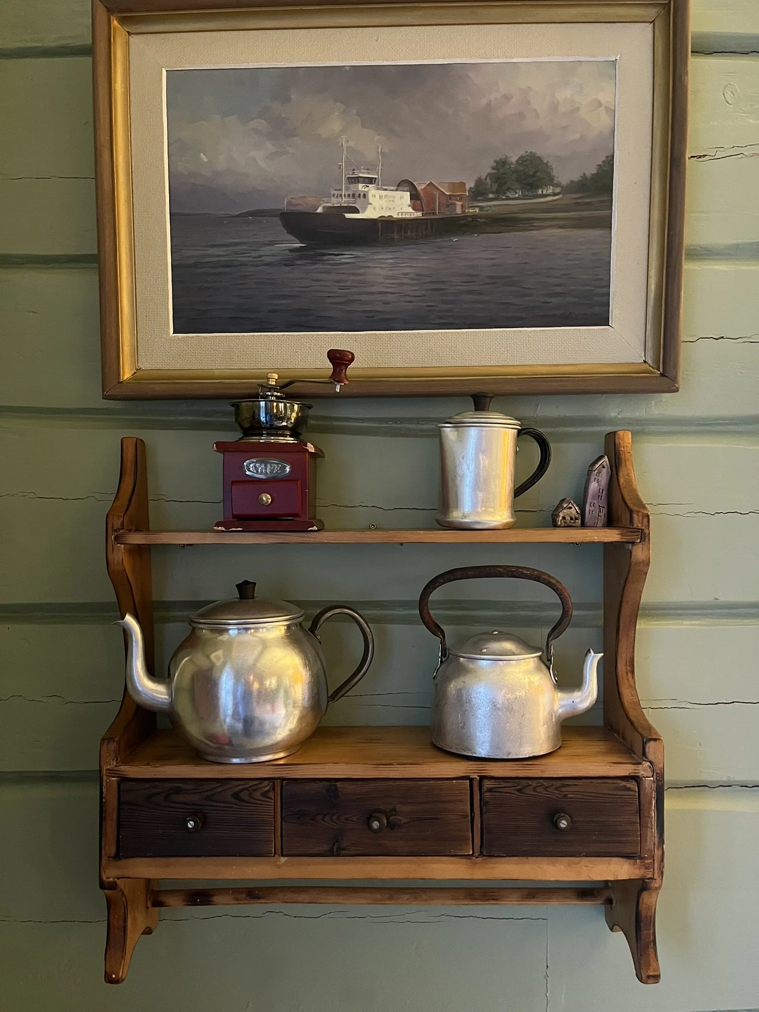 Kaffehylla som broren snekret på sløyden, pynter opp veggen i kaffebaren.