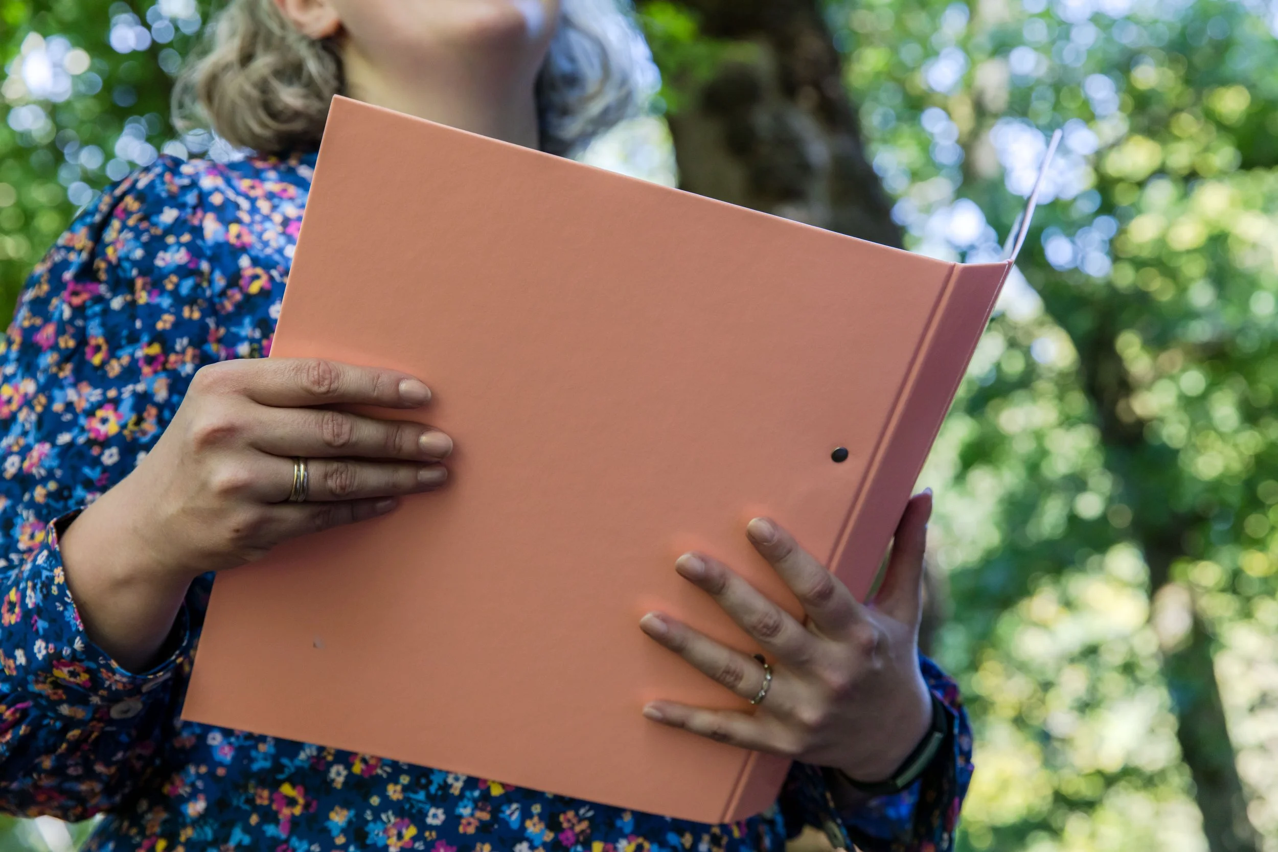 Claire Dunford Celebrant holding peach coloured ceremony folder