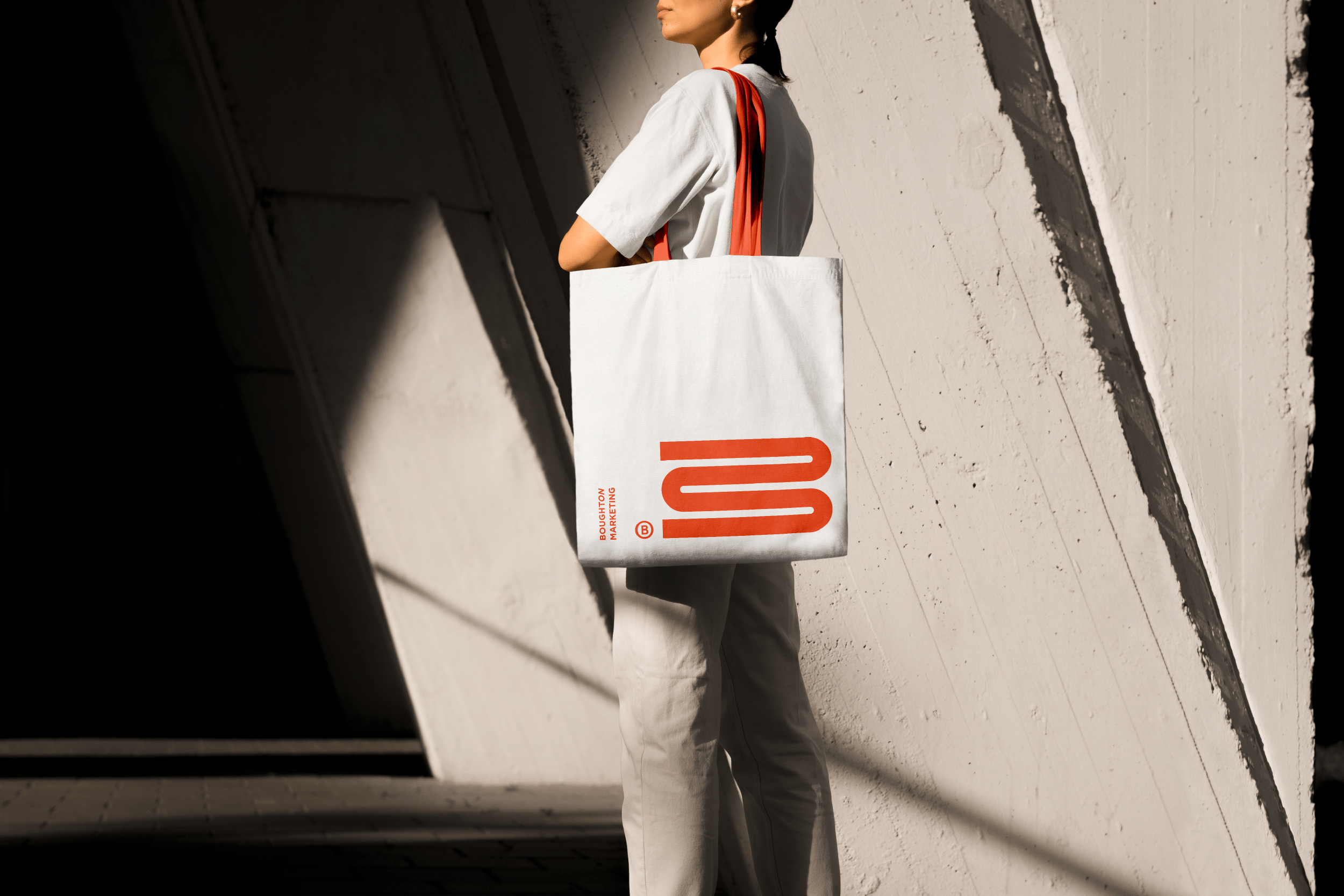 Woman with a Boughton Marketing tote bag featuring the Boughton graphic brand marque, a stylised 'B' that is also an 'M'.