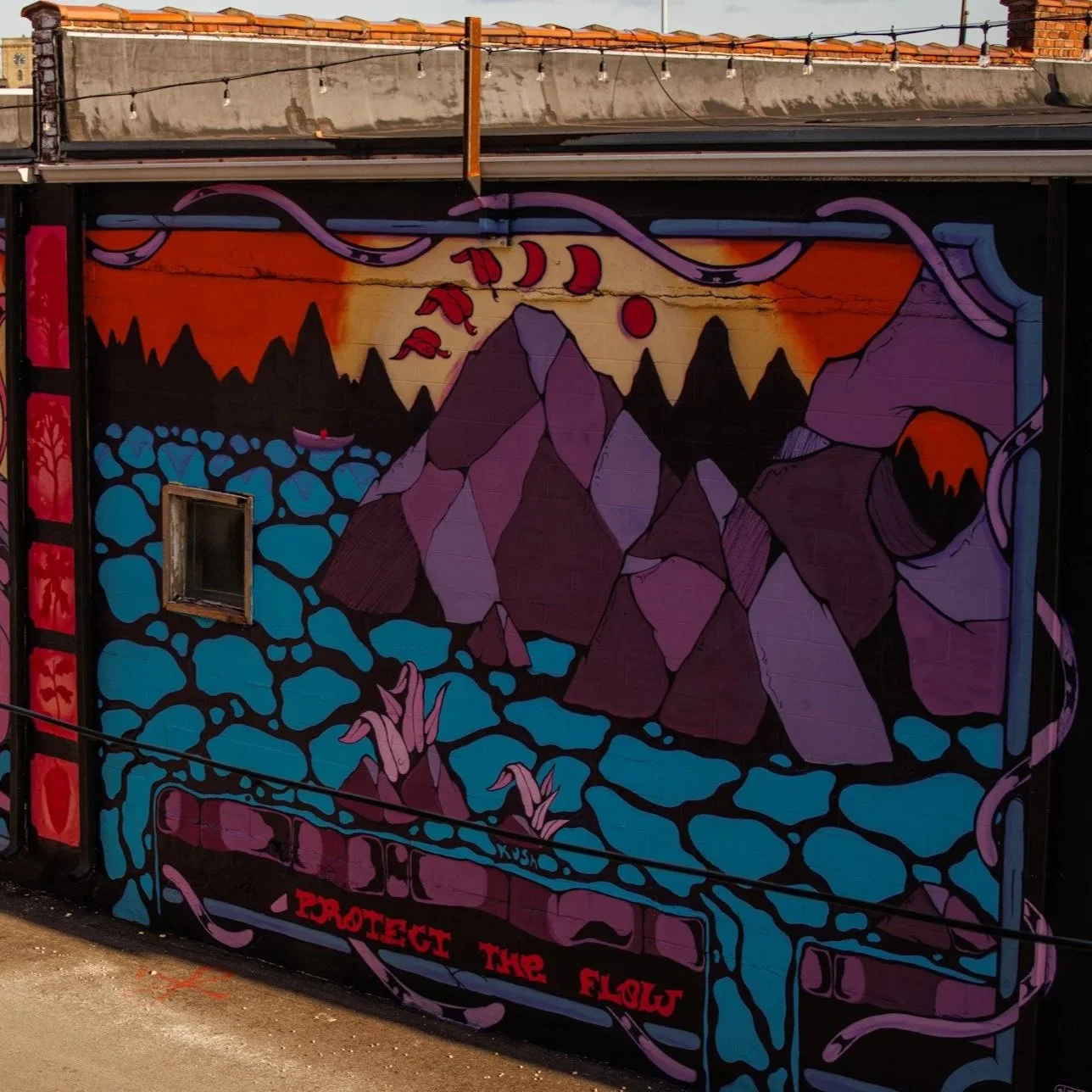 Mural colorido com uma cena de natureza com montanhas rochosas, um rio azul e um pôr do sol, com a frase 'Proteja a Flora' na parte inferior.