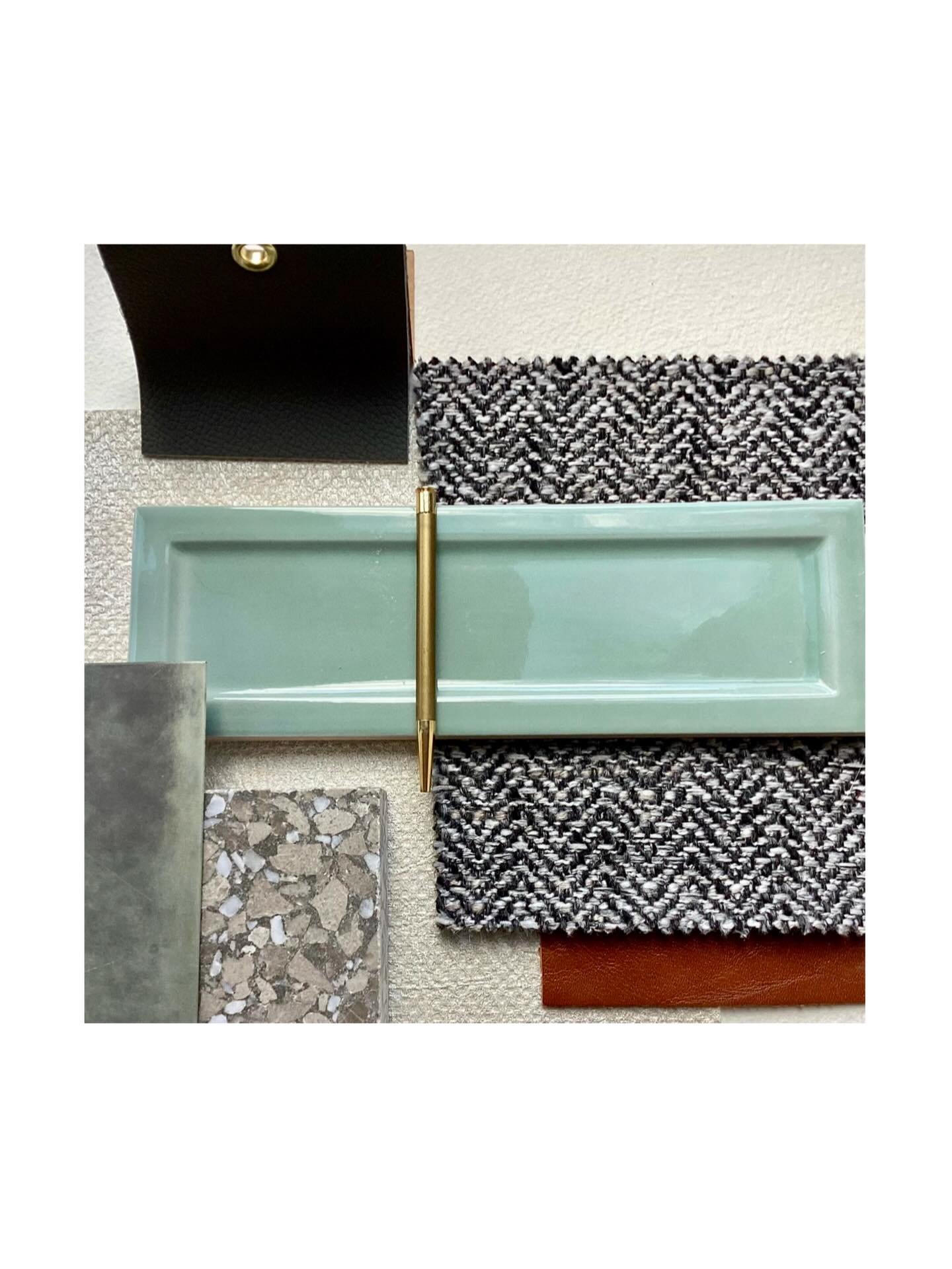 Bold. Textured. Effortlessly Balanced.
Retro blue tiles meet warm black &amp; white herringbone upholstery, creamy textured walls, and terrazzo plinths, layered with weathered grey metal finishes for a subtle gleam.

Deep burgundy curtains and dark g